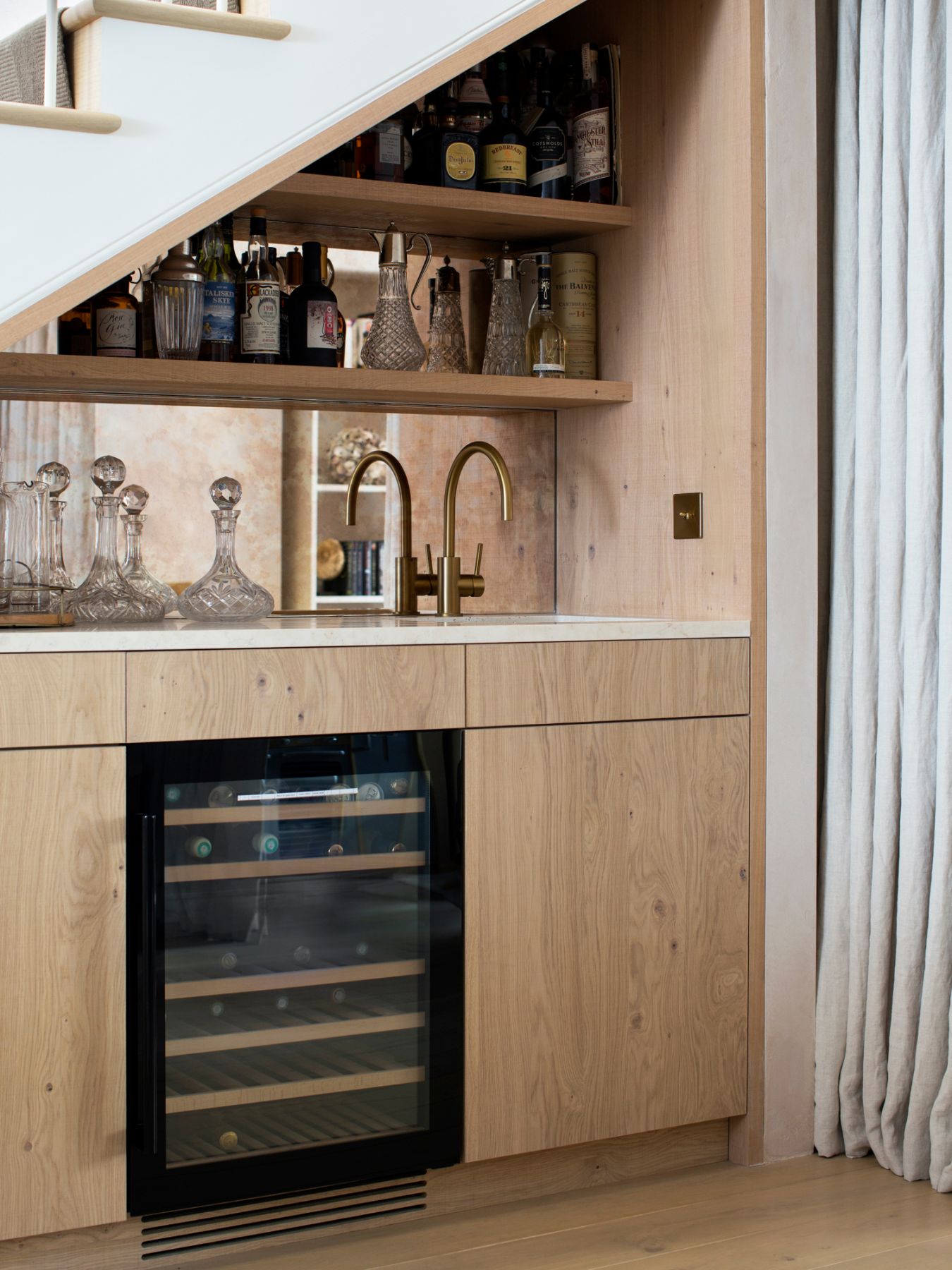 Beautiful and functional, a custom cocktail area is tucked under the staircase