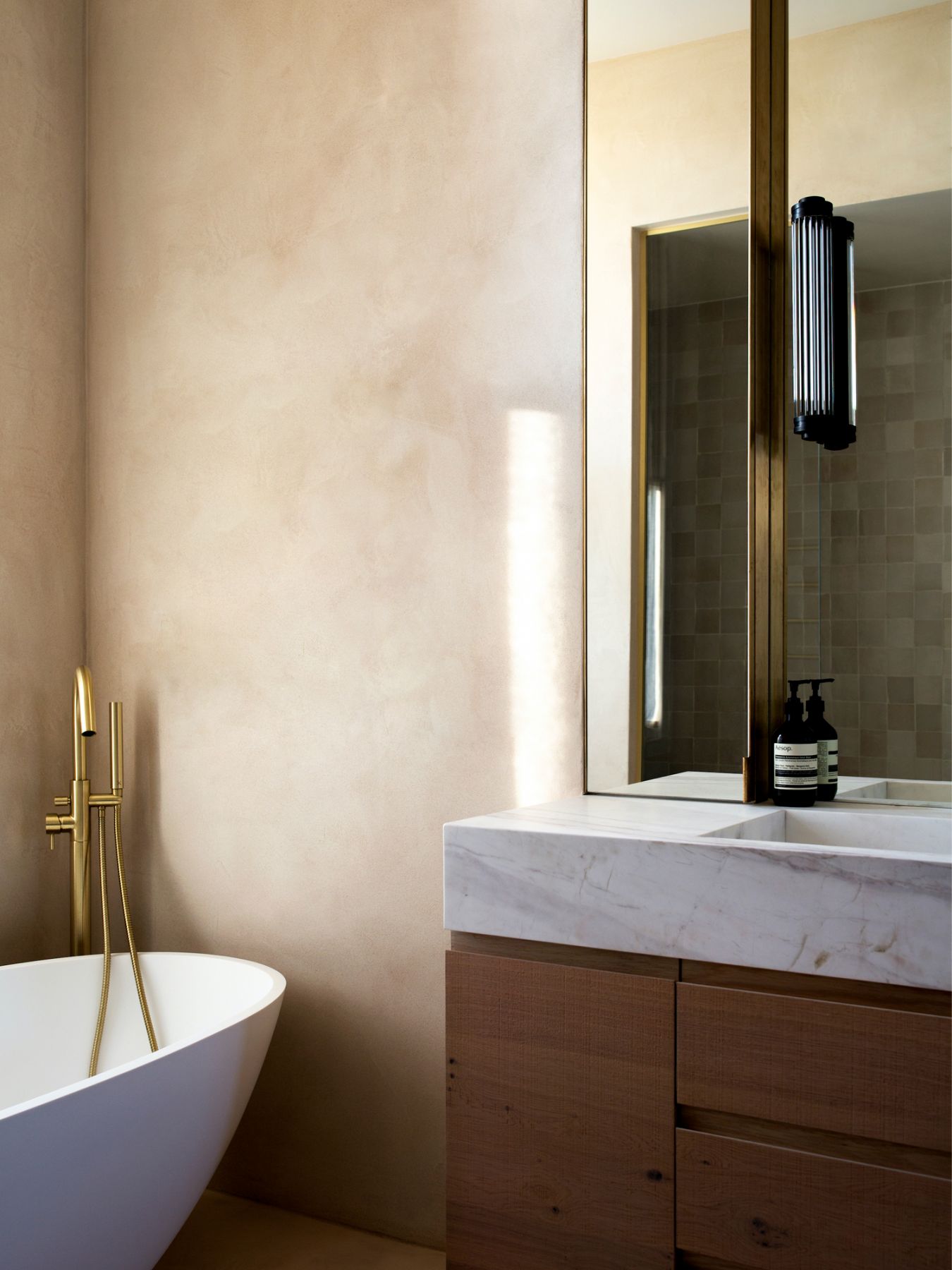 The idyllic bathroom features a free-standing bath with textured walls and panels