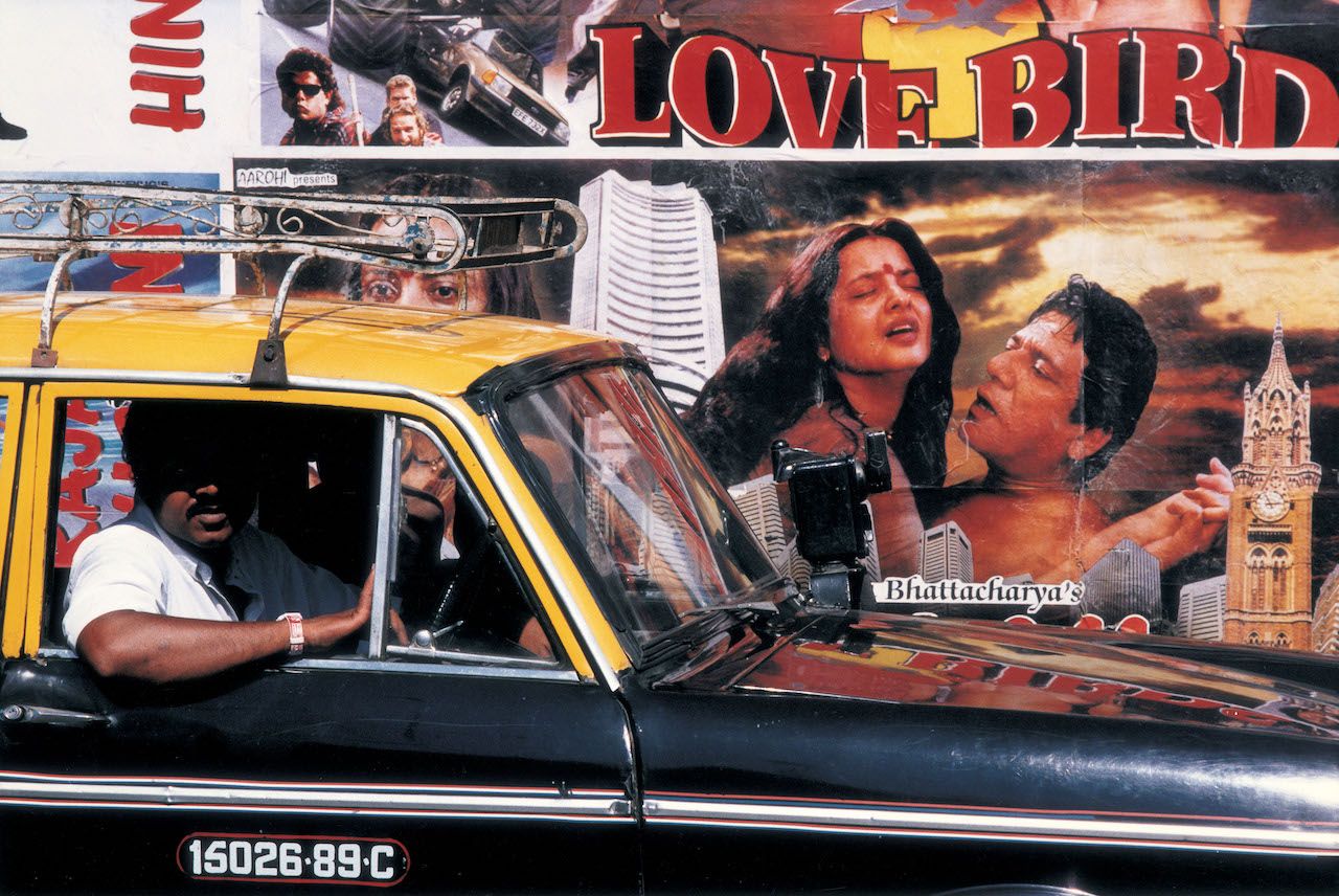 MUMBAI, INDIA - JANUARY 1997: Outside Churchgate station in Mumbai, the walls are covered with promotional advertisements for Bollywood films January 1997 in Mumbai, India. (Photo by Jonathan Torgovnik/Getty Images)