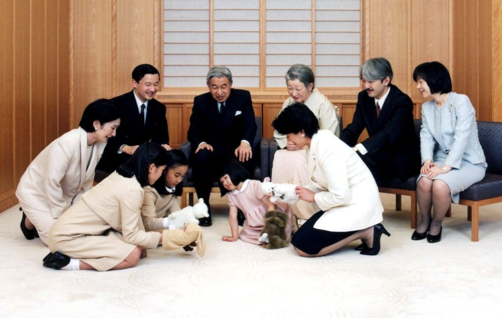 This Imperial Palace official photo distributed by the Imperial Household Agency, Japanese Emperor Akihito, seated on a chair second from left, and Empress Michiko, seated center, and their family members look on Princess Aiko, daughter of Crown Prince Naruhito, seated on a chair at left, and Crown Princess Masako, kneels down on the floor at right, play with Princess Mako, kneeling down foreground, and Princess Kako, daughters of Prince Akishino, seated on a chair second from right, and Princess Kiko, knee