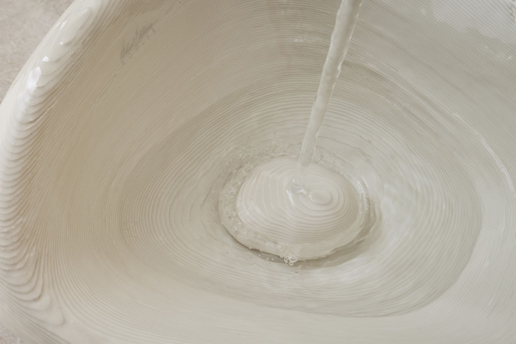 The pebble-like sink is inspired by timeworn stones along the beach near Arsham's home