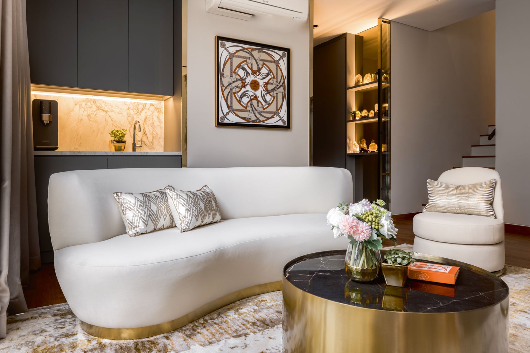Curvy furnishings add a cosy touch to the lounge area, which also features the daughter’s crystal collection on the backlit shelves