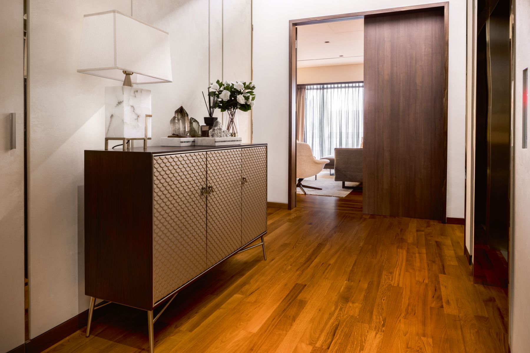 A sideboard with scallop-patterned doors brings an art deco touch to this passageway