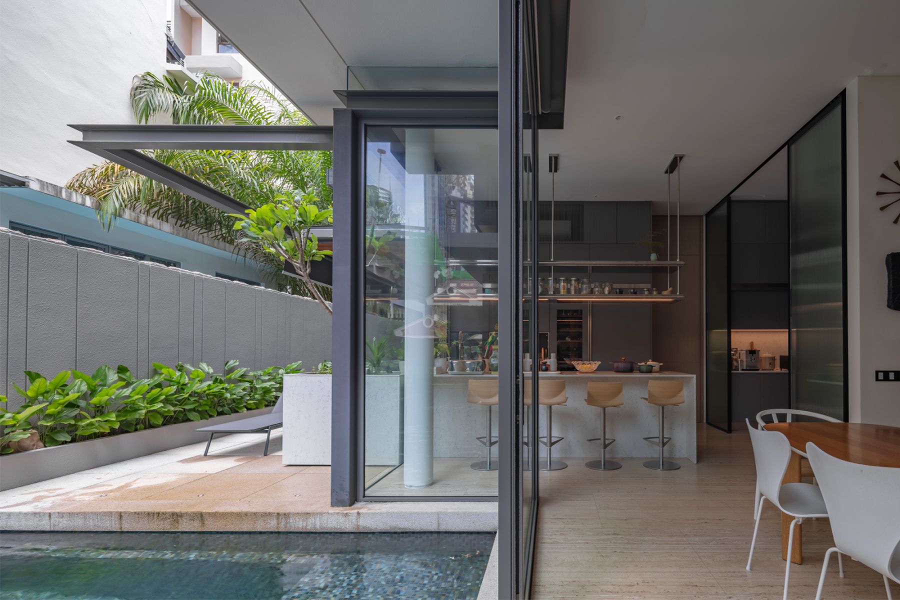 The contemporary dining and kitchen zone features easy access to the swimming pool and beyond