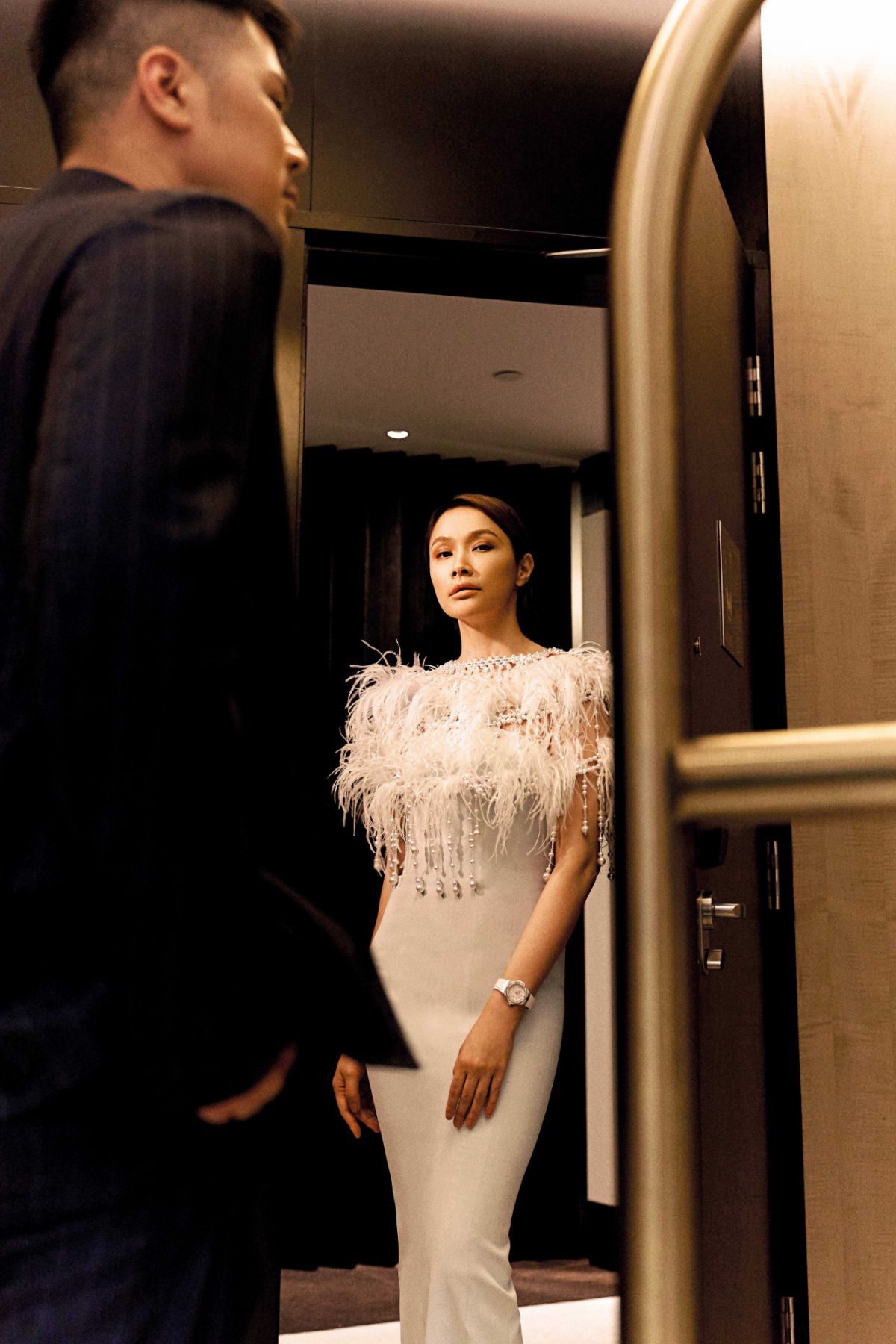 Awal wears outfit from Salvatore Ferragamo; Scha wears dress from Ivan Young and watch from Hublot