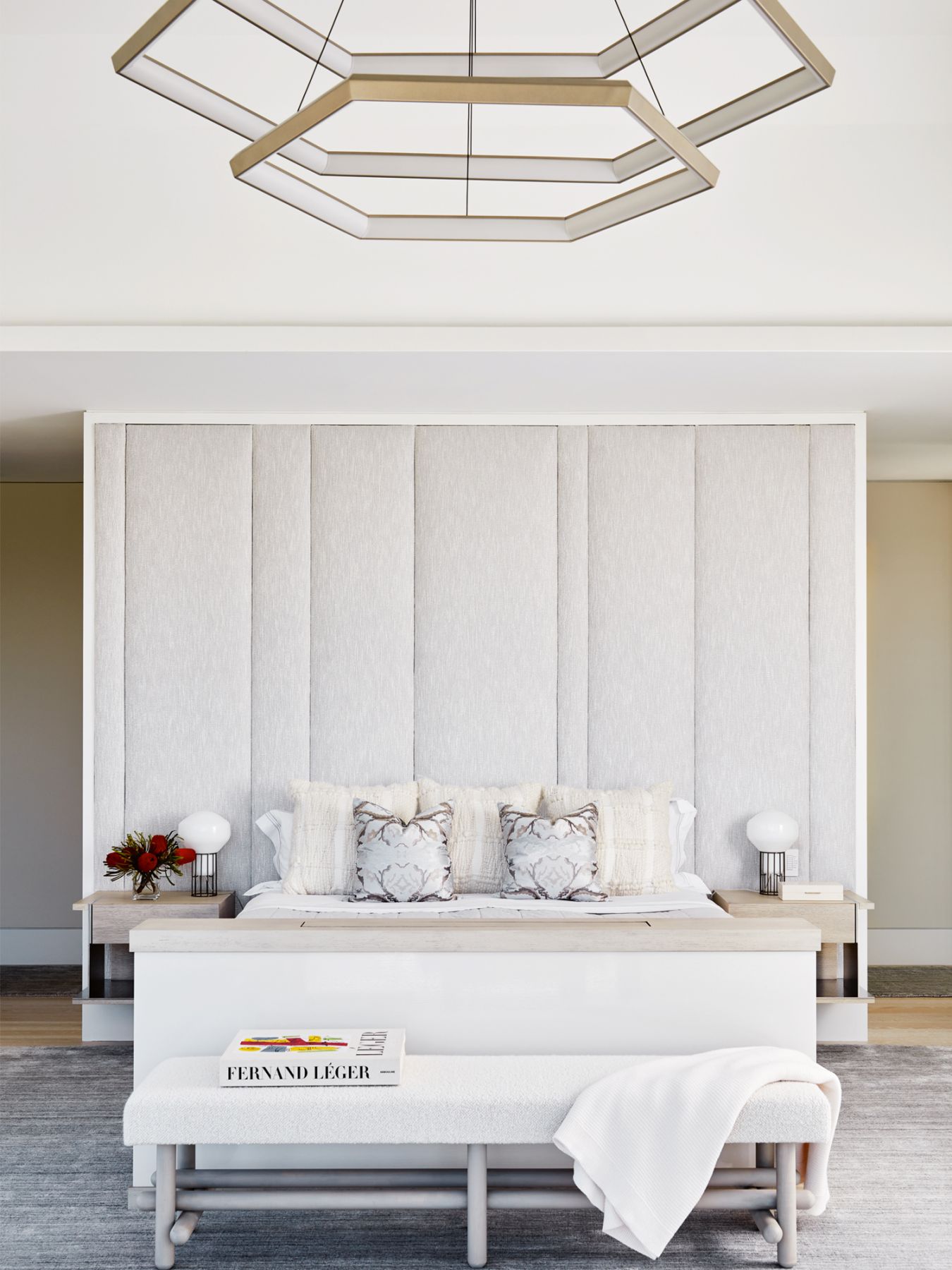 The master bedroom features a stunning chandelier from Studio Endo, a rug from Van Den Loom, as well as a bed and night stands custom-made by Pembrooke & Ives