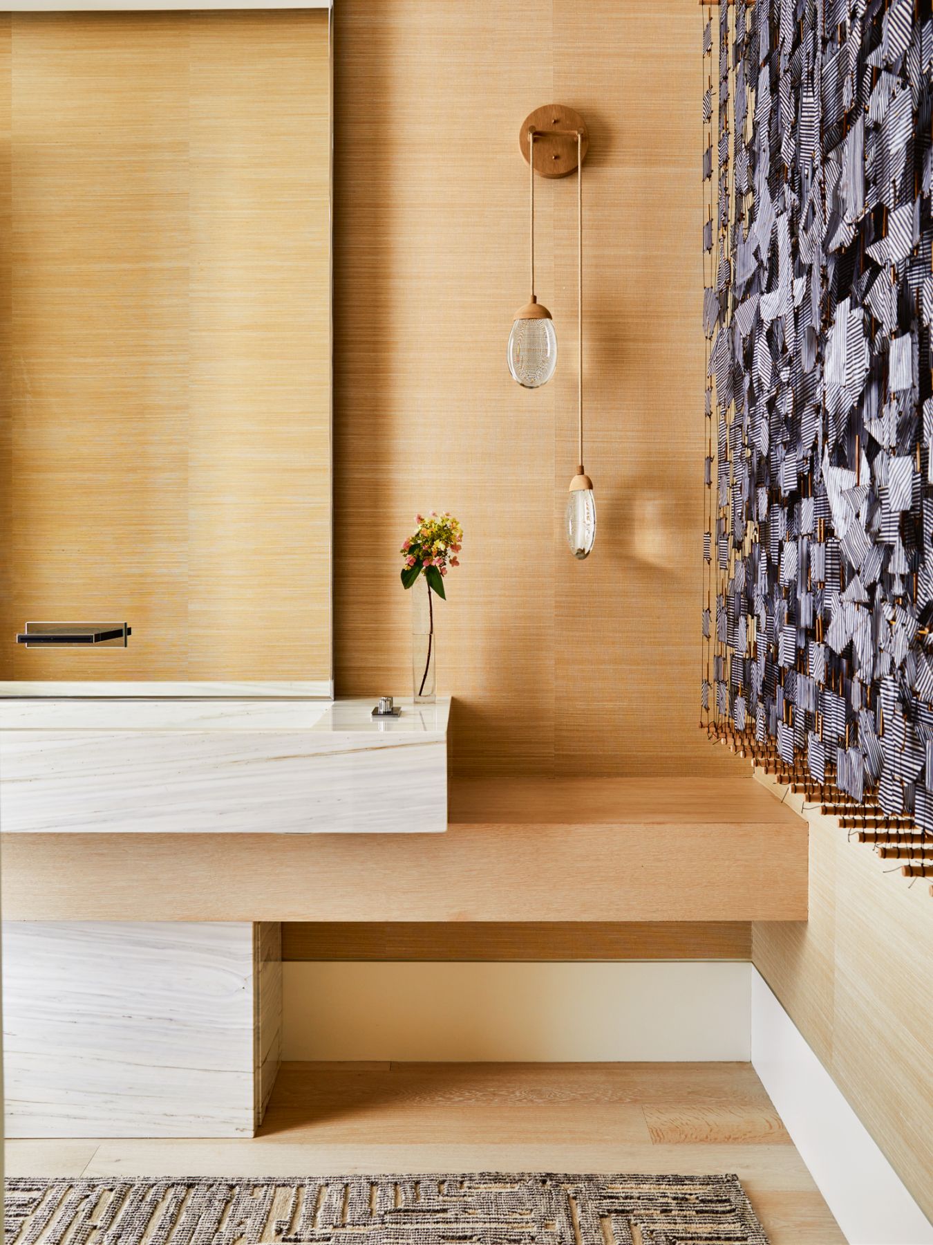 Light wood panels and Ochre sconces provide a tranquil backdrop for a work by Jacob Hashimoto displayed in the powder room