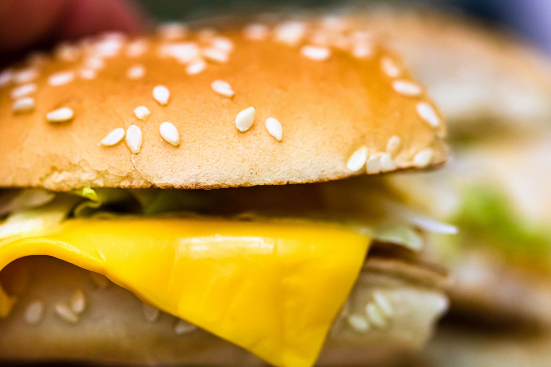 Close up detail of a bitten cheeseburger. Food, junk food and fast food concept