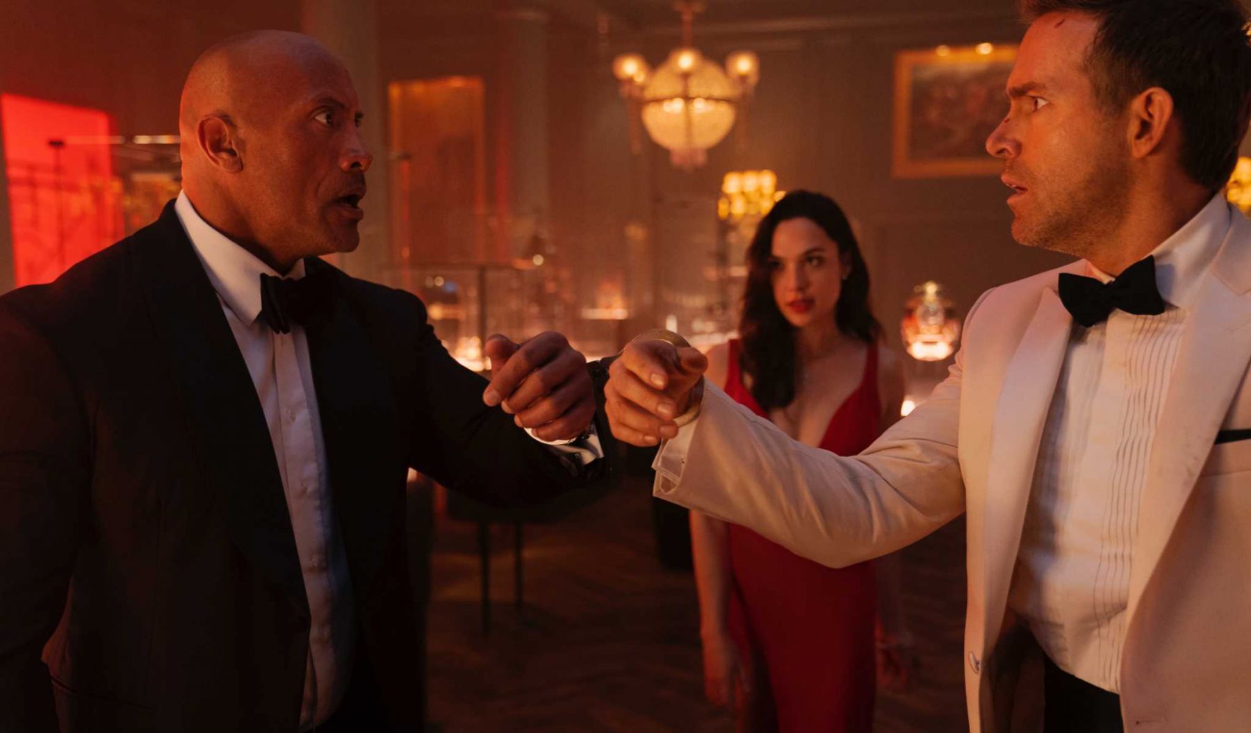 RED NOTICE - (L-R) Dwayne Johnson is the FBIâs top profiler John Hartley, Gal Gadot is the worldâs most wanted art thief âThe Bishopâ and Ryan Reynolds is the worldâs greatest art thief Nolan Booth in Netflix's RED NOTICE. Directed and written by Rawson Marshall Thurber, RED NOTICE is releasing November 12, 2021. Cr: Frank Masi / Netflix © 2021