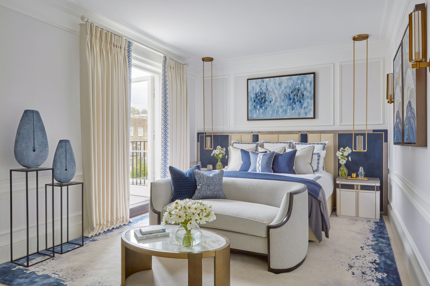 The statement headboard in the master bedroom matches with the bespoke bedside tables handcrafted in straw marquetry