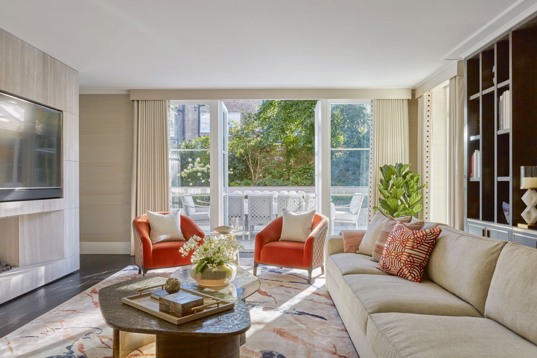 The sprightly orange tones of the furnishings, art and accent pieces visually connect the living and dining areas