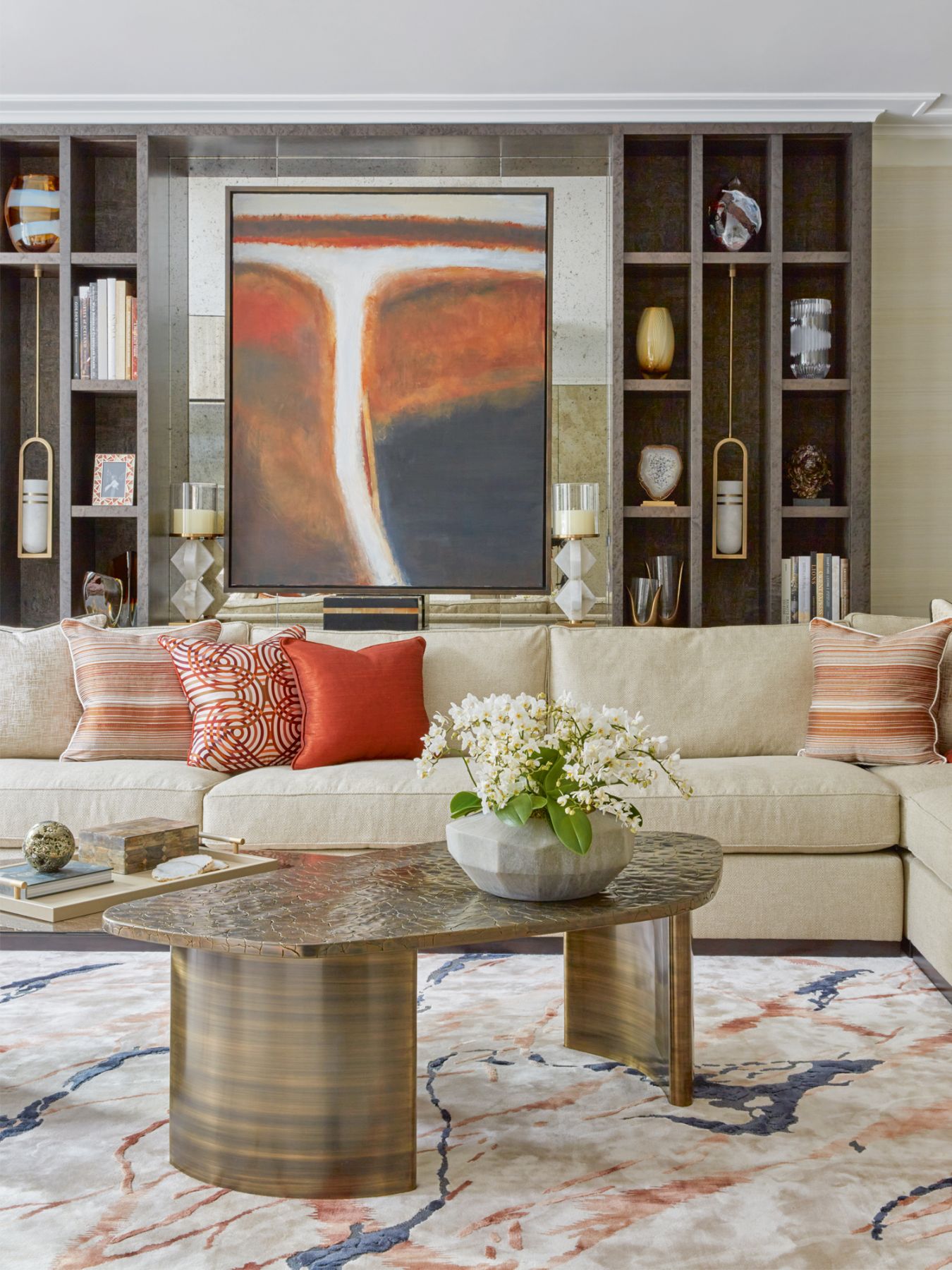 The sprightly orange tones of the furnishings, art and accent pieces visually connect the living and dining areas