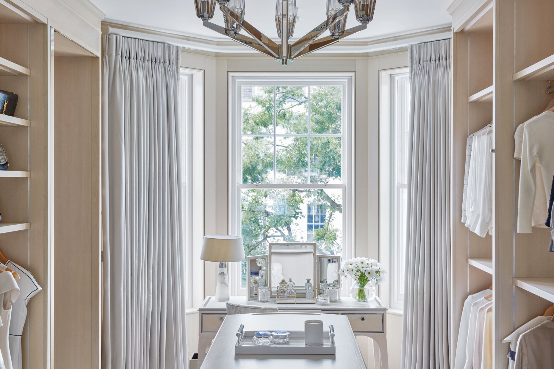 An off-white palette creates a refined look for the walk-in closet
