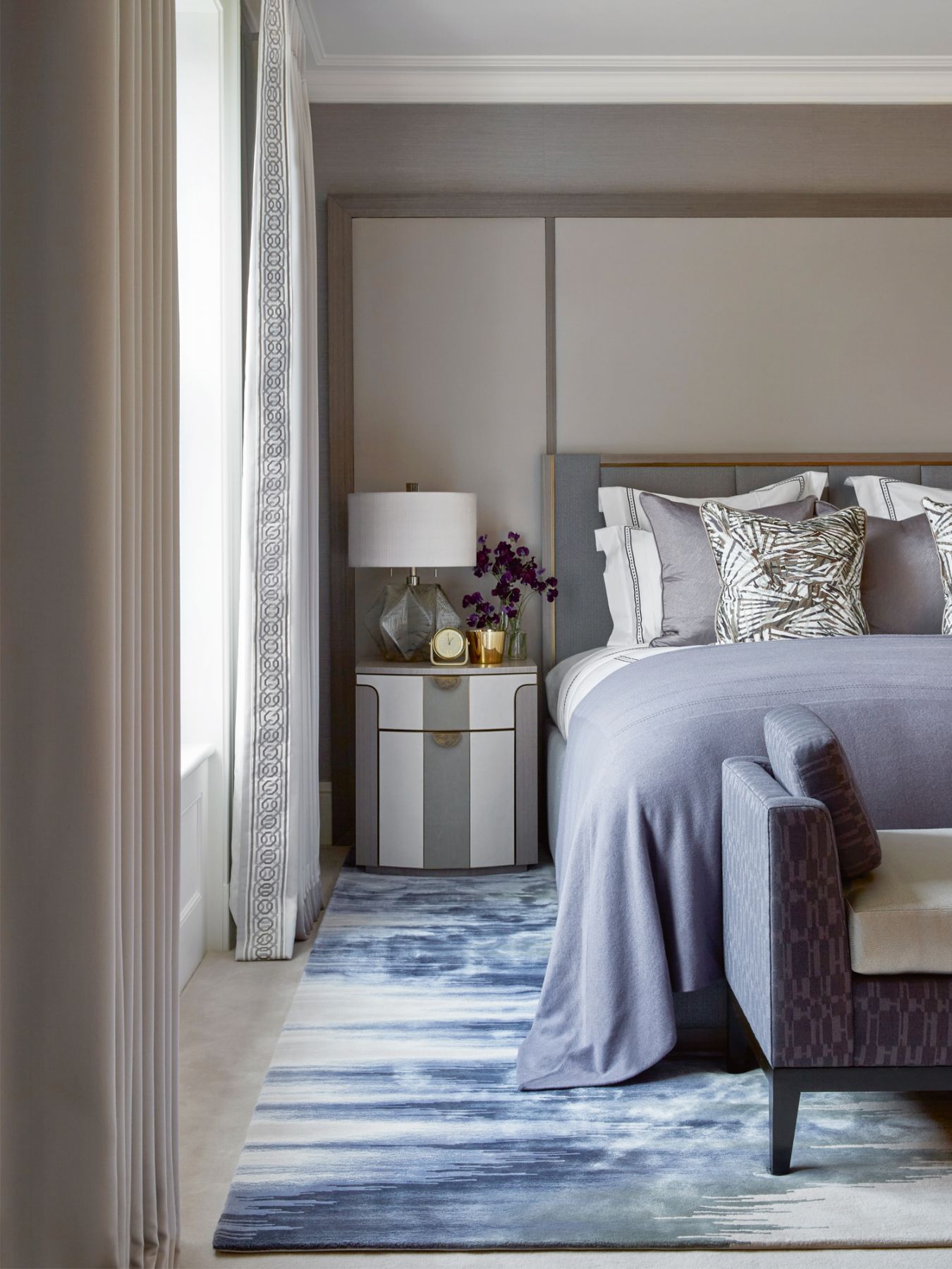 A plush mix of bedlinen and furnishings in blue and grey tones creates a calming mood in this guest room