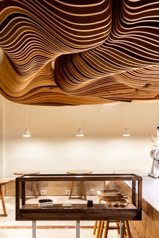 The undulating wooden ceiling is makes a visual statement in the cafe (Image: Feelament)