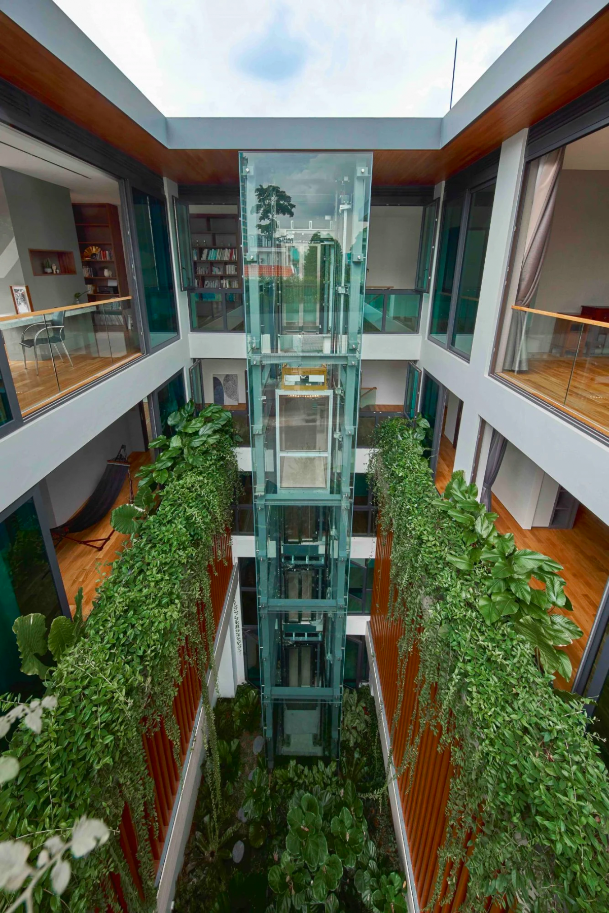 The courtyard of the home is filled with verdant greens that can be viewed through the glass elevator (Photography: Jasper Yu)