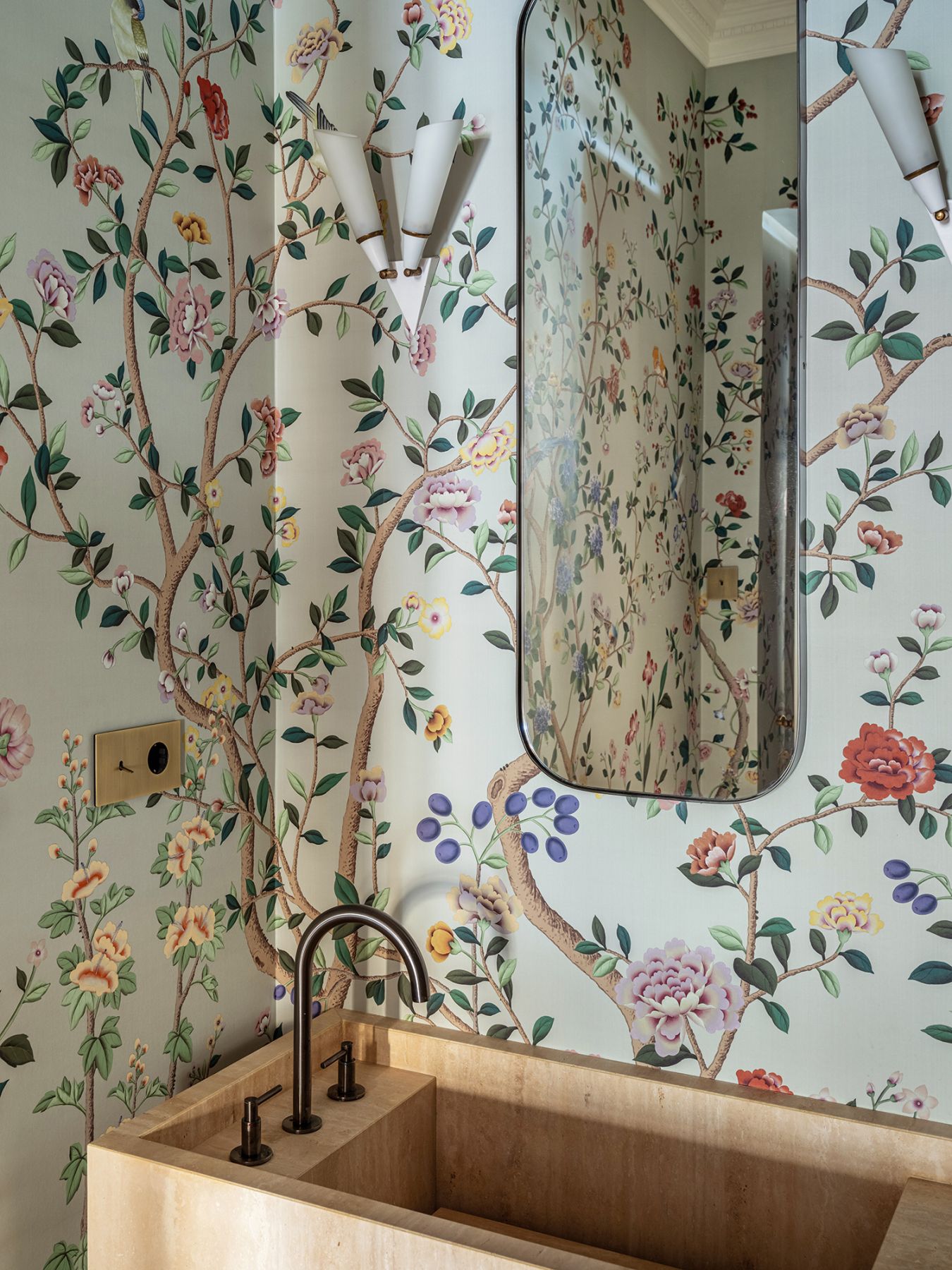 The floral blooms on the wallpaper brings the powder room to life
