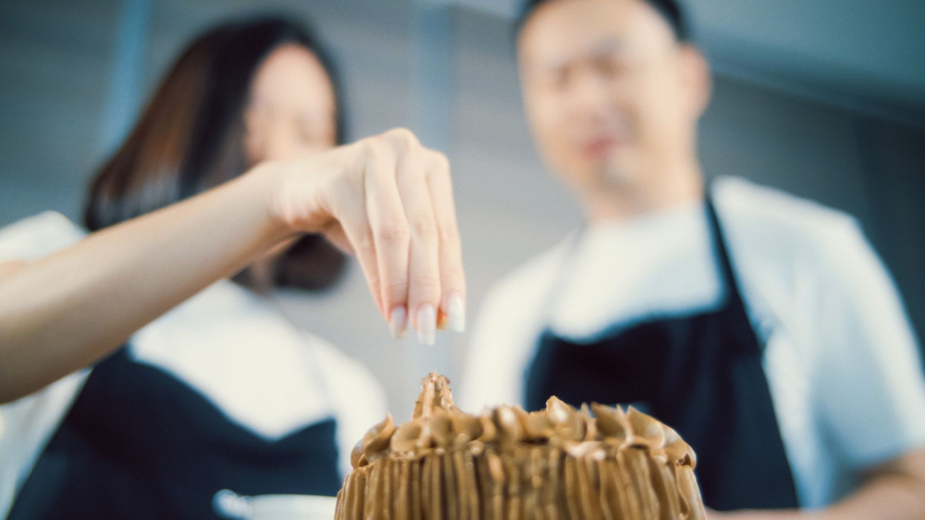 Hartono and Kong decorating a chocolate cake together