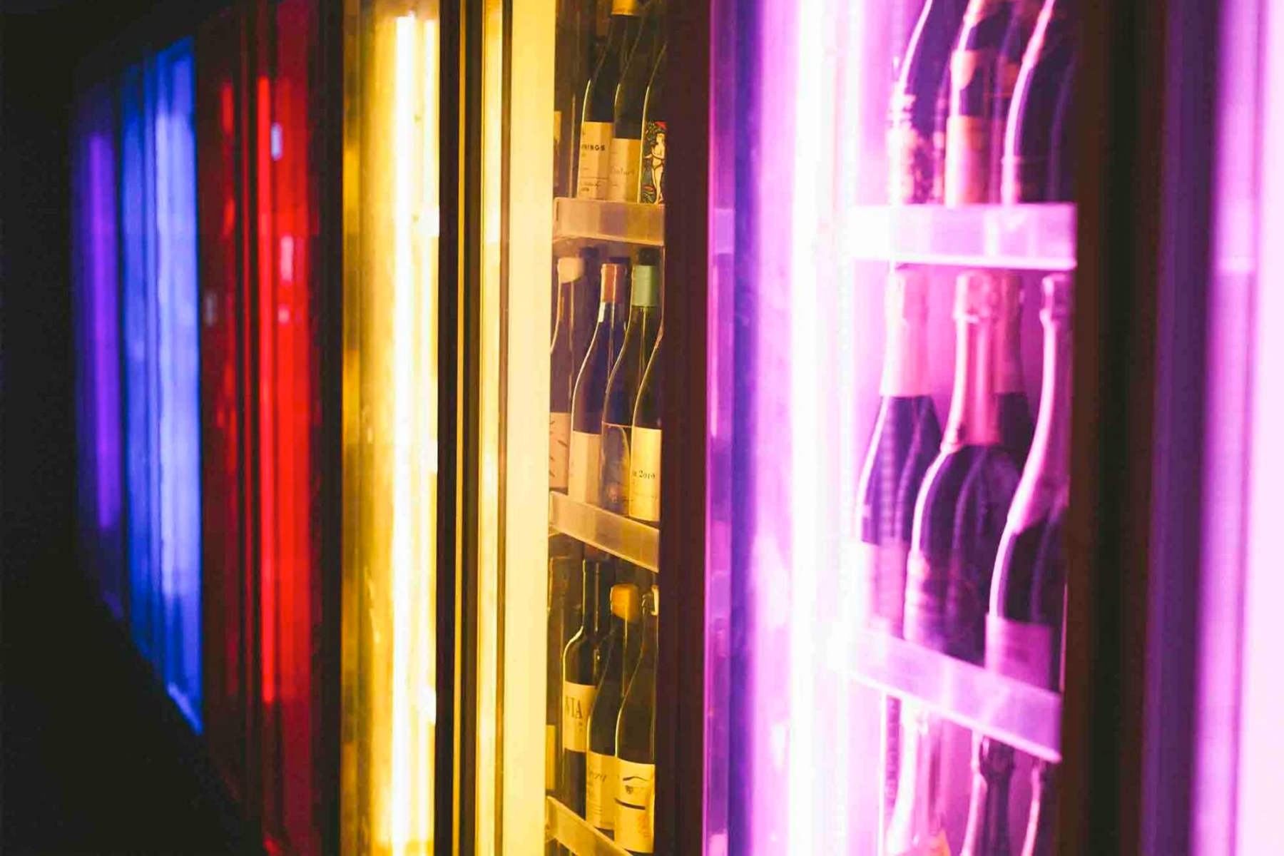 The restaurant's wine hall is a futuristic space where wine coolers are lighted up in rainbow hues (Image: Corduroy Palace)