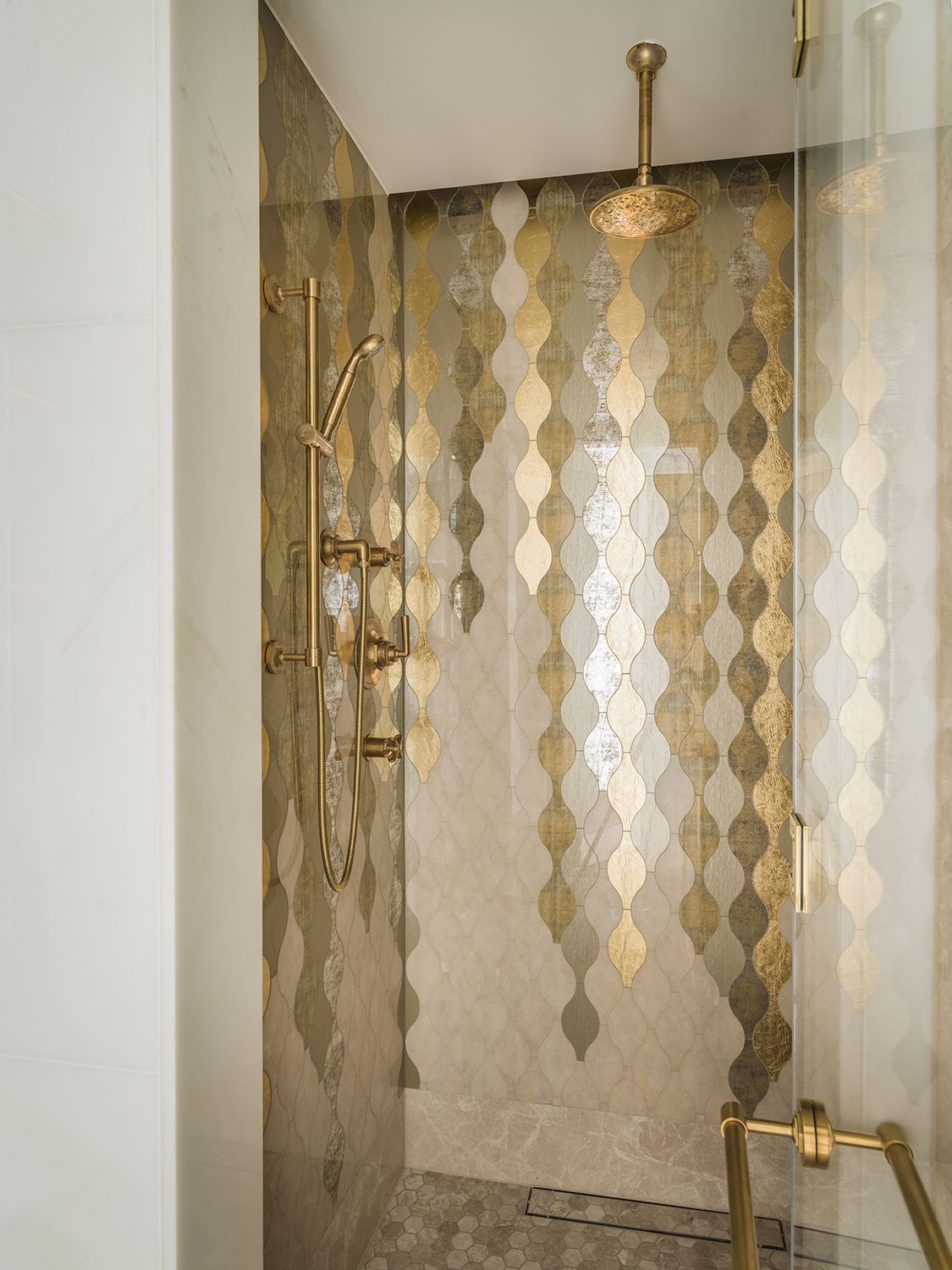 The glass mosaic, sourced from Sicis, adds a gleaming touch to the shower