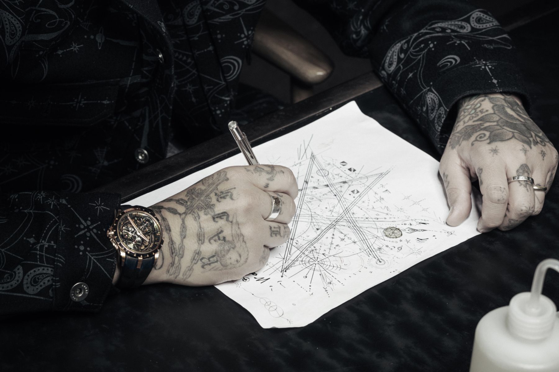 Renowned tattoo artist drafting the design detailings for the new Roger Dubuis Excalibur Dr. Woo Monotourbillion timepiece