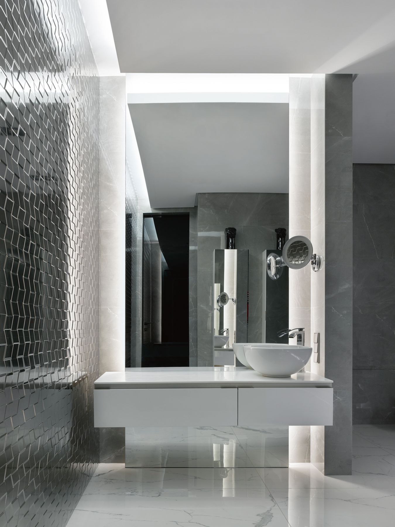 Geometric wall tiles add texture to the elegant monochromatic palette of this bathroom