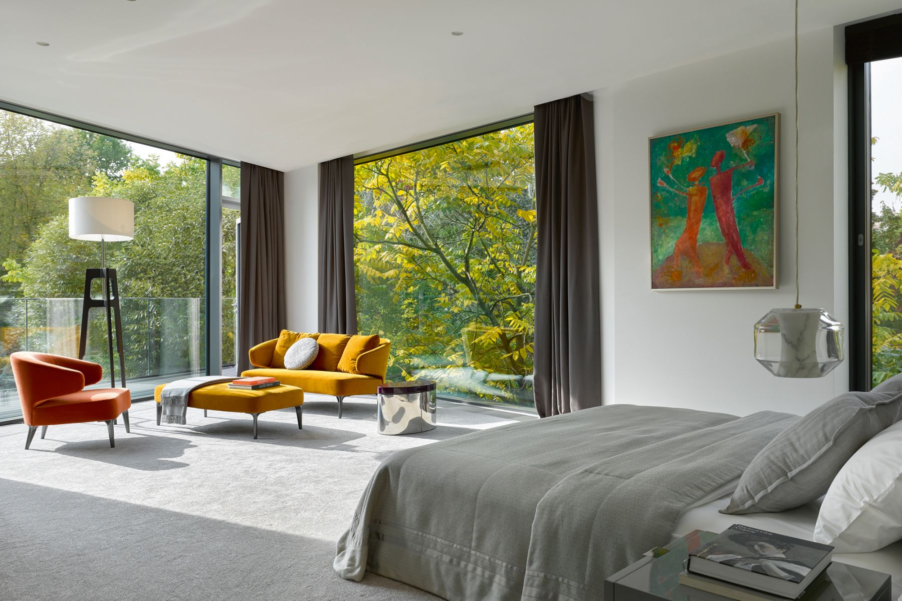 In this bedroom, the leather armchair as well as the mustard yellow Minotti sofa and ottoman echo the warm tones of a painting from the owners’ art collection