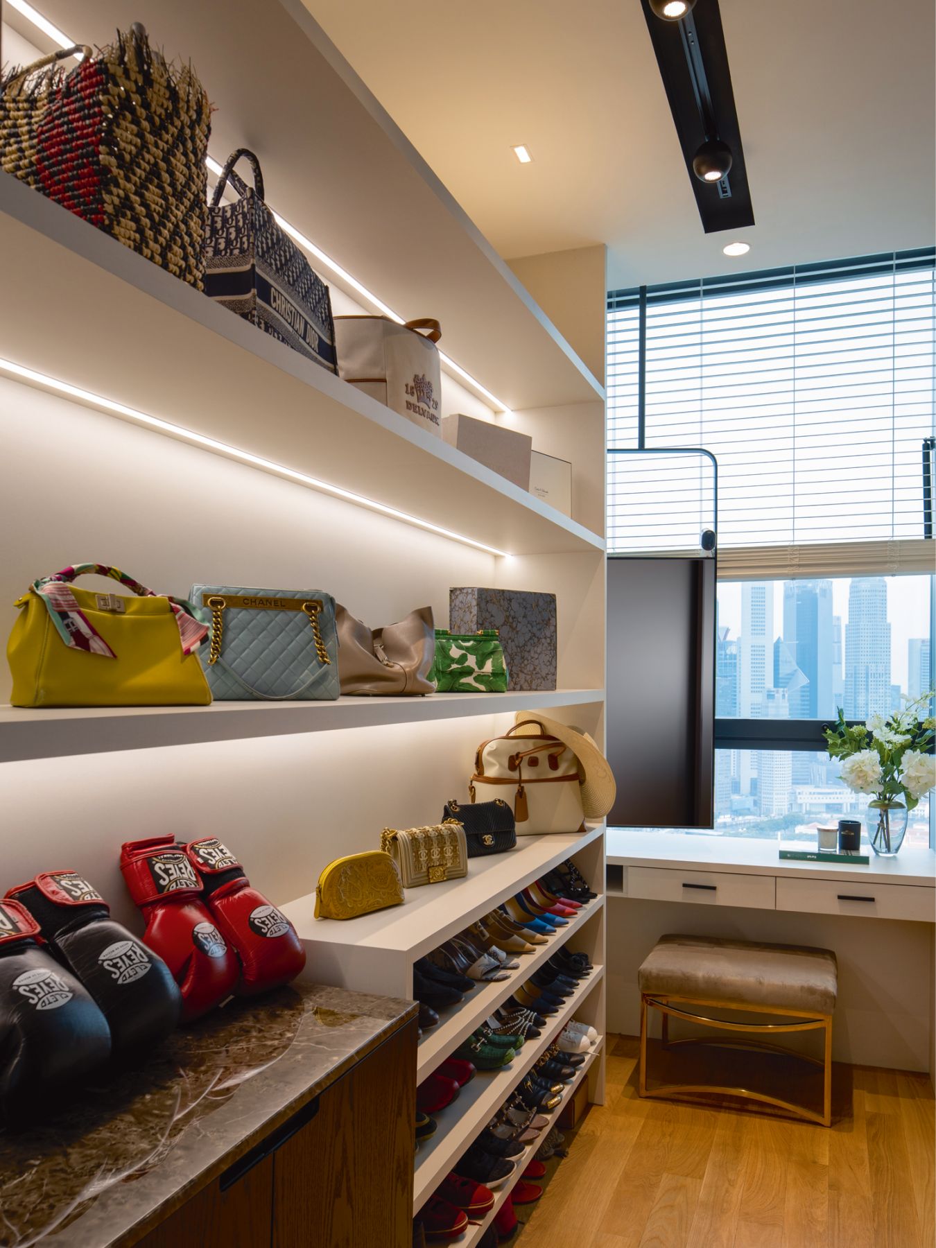 These open shelves in the wardrobe area showcase the wife’s extensive collection of bags and shoes, as well as the husband’s boxing gloves