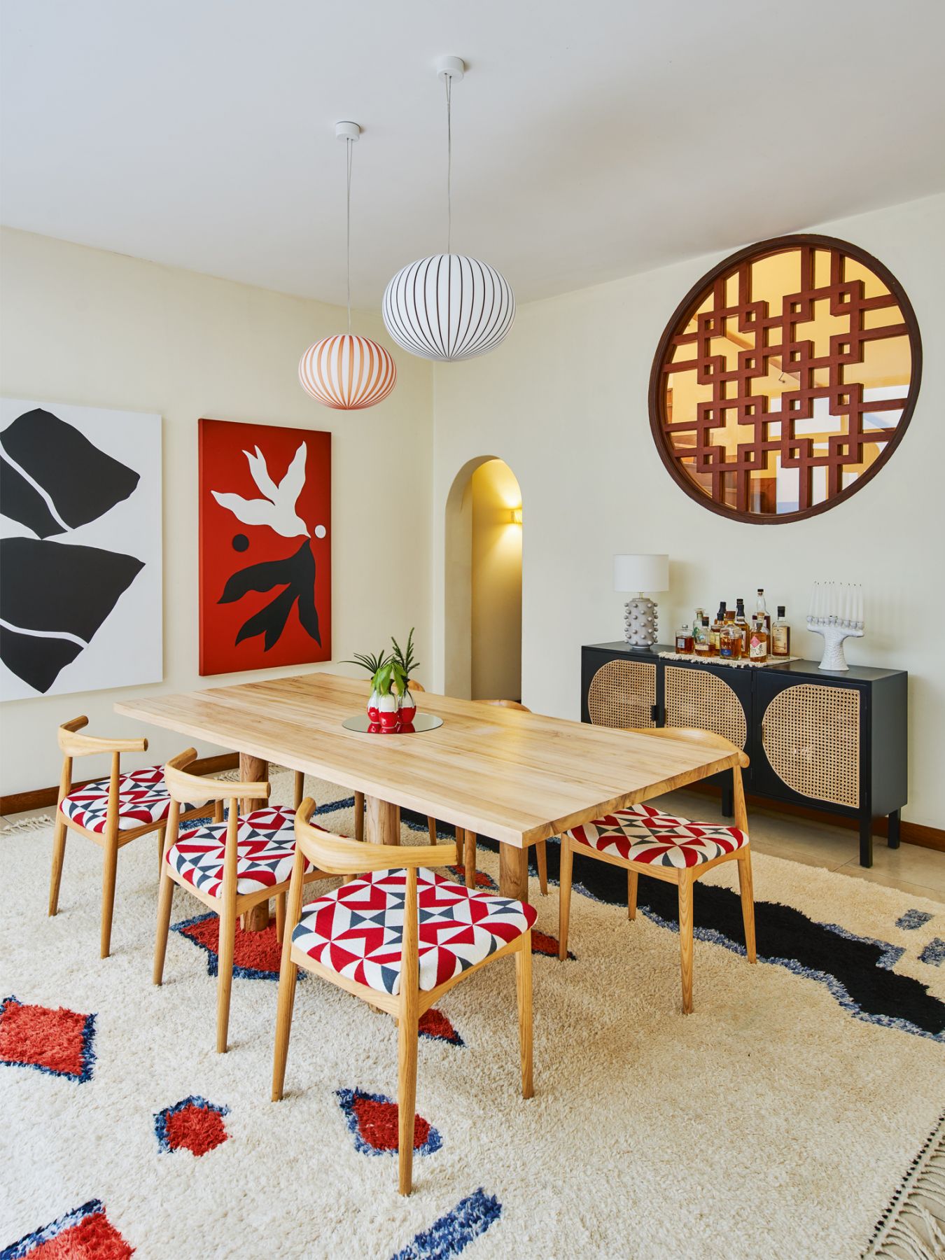 The dining area features chairs from Habitat, reupholstered by Bode Fabrics & Furnishings, a custom dining table and a sideboard from Rooma, and pendant lamps from Established & Sons