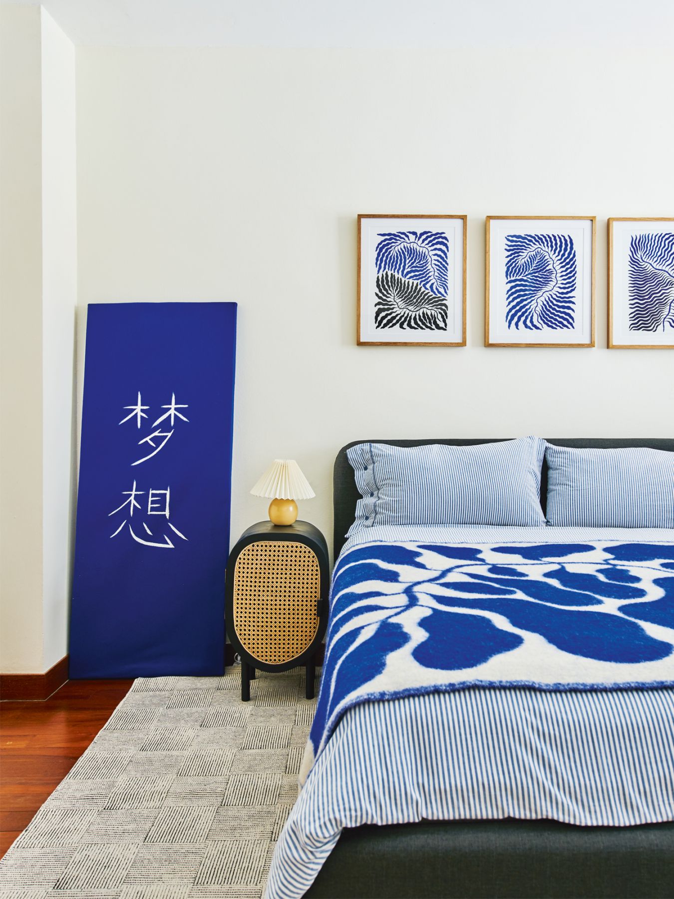 The blue hues of the artworks and bedlinen create a serene look in this bedroom