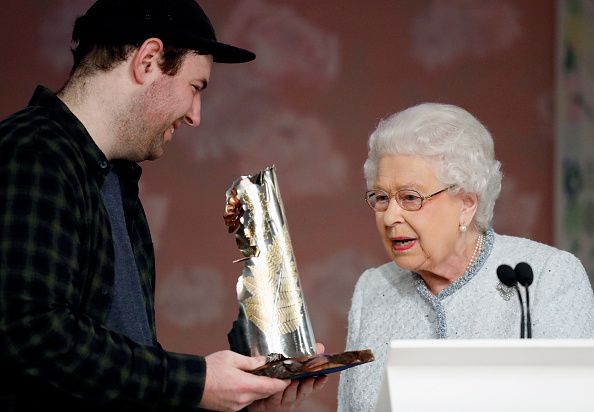 LONDON, ENGLAND - FEBRUARY 20: Queen Elizabeth II (R) awards designer Richard Quinn (L) the inaugural Queen Elizabeth II award for British Design during London Fashion Week February 2018 on February 20, 2018 in London, England. (Photo by Tristan Fewings/BFC/Getty Images)