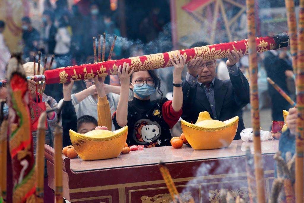 NANNING, CHINA - FEBRUARY 16: People pray with incense sticks at the Confucius Temple on the fifth day of the Chinese New Year, the Year of the Ox, on February 16, 2021 in Nanning, Guangxi Zhuang Autonomous Region of China. Chinese people hold activities to welcome the God of Wealth on the fifth day of the first lunar month. (Photo by Lai Jian/VCG via Getty Images)