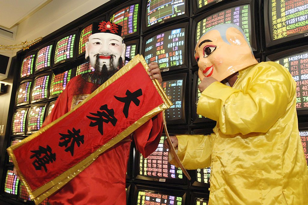 TAIPEI, TAIWAN - 2006/02/03: Actors dressed as Tsai Hsen-yeh, the God associated with money in the Chinese pantheon (red robe), and his assistant, welcome investors and traders inside Taiwan Securities building in occasion of the first day trading after the Chinese New Year Holiday.. (Photo by Alberto Buzzola/LightRocket via Getty Images)