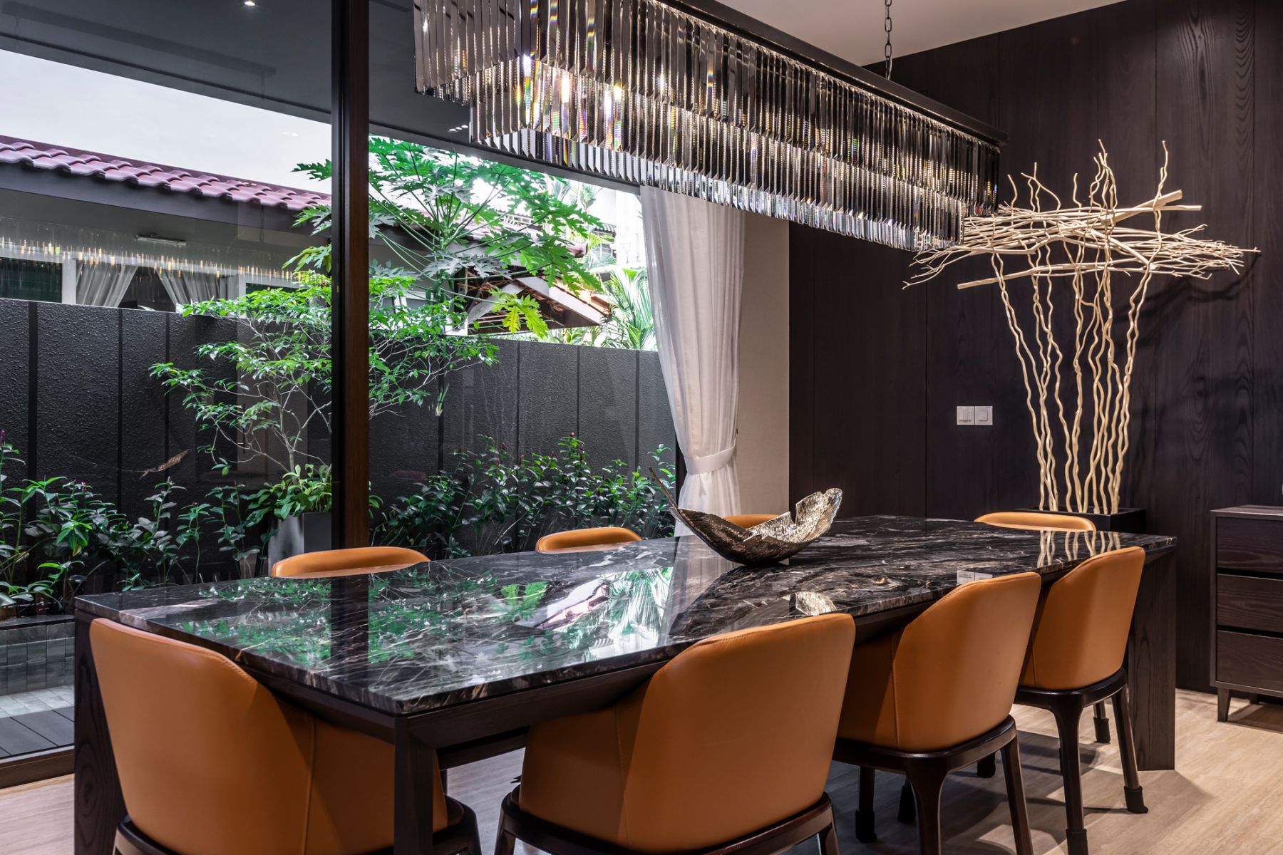 The dining room is furnished with a handsome mix of marble, leather and statement lighting pieces