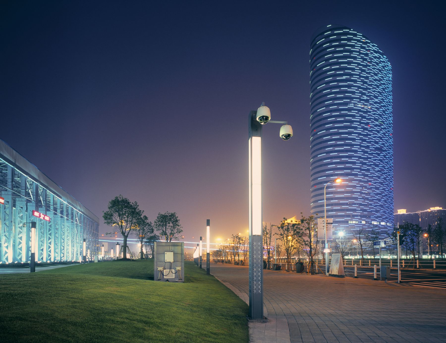 Shanghai by night with futuristic LED lit building and surveillance camera's.