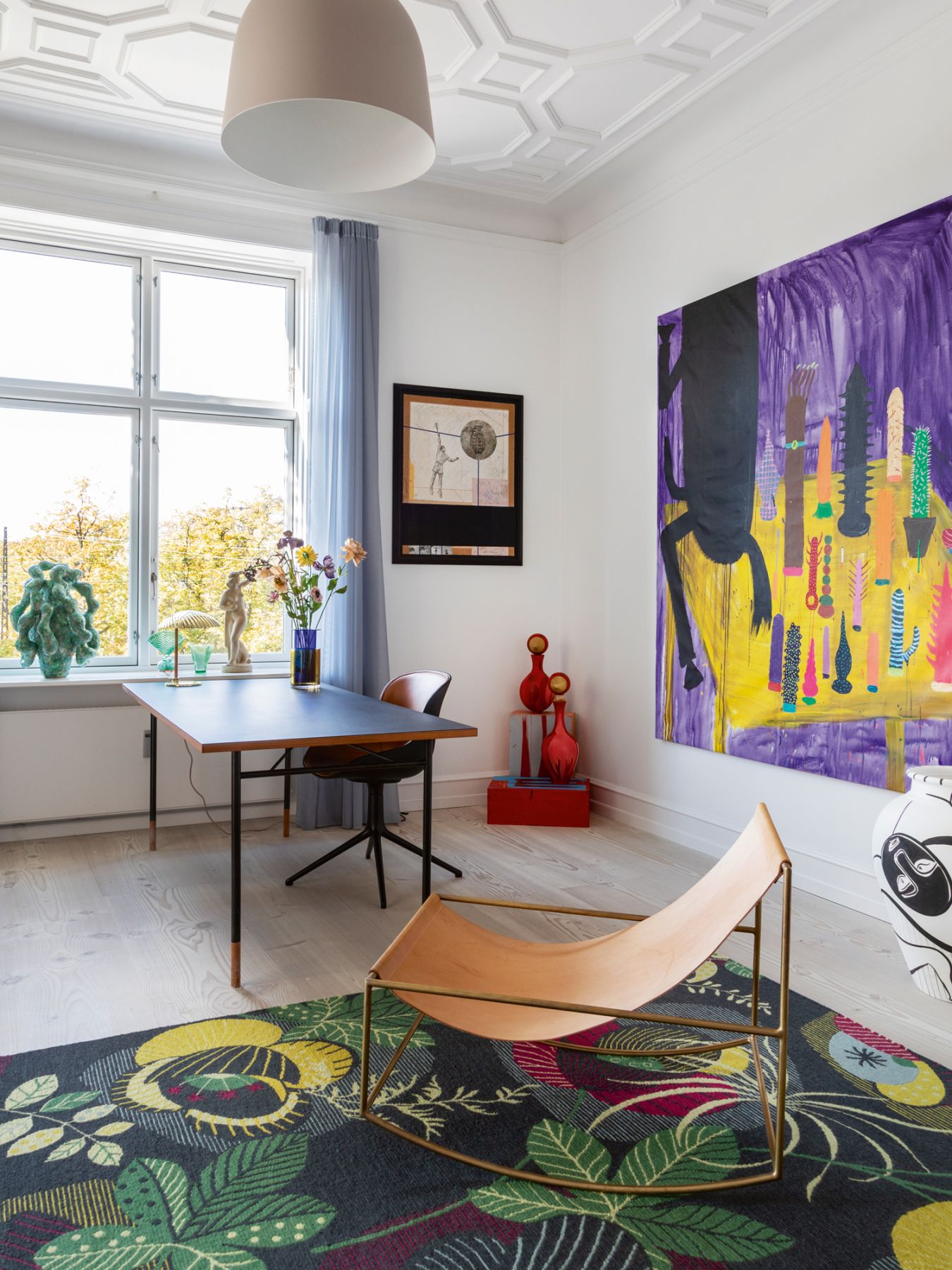 In the study, a Finn Juhl-designed desk is paired with a lamp and chair by Normann Copenhagen and a large painting by Frederik Nøbelrød