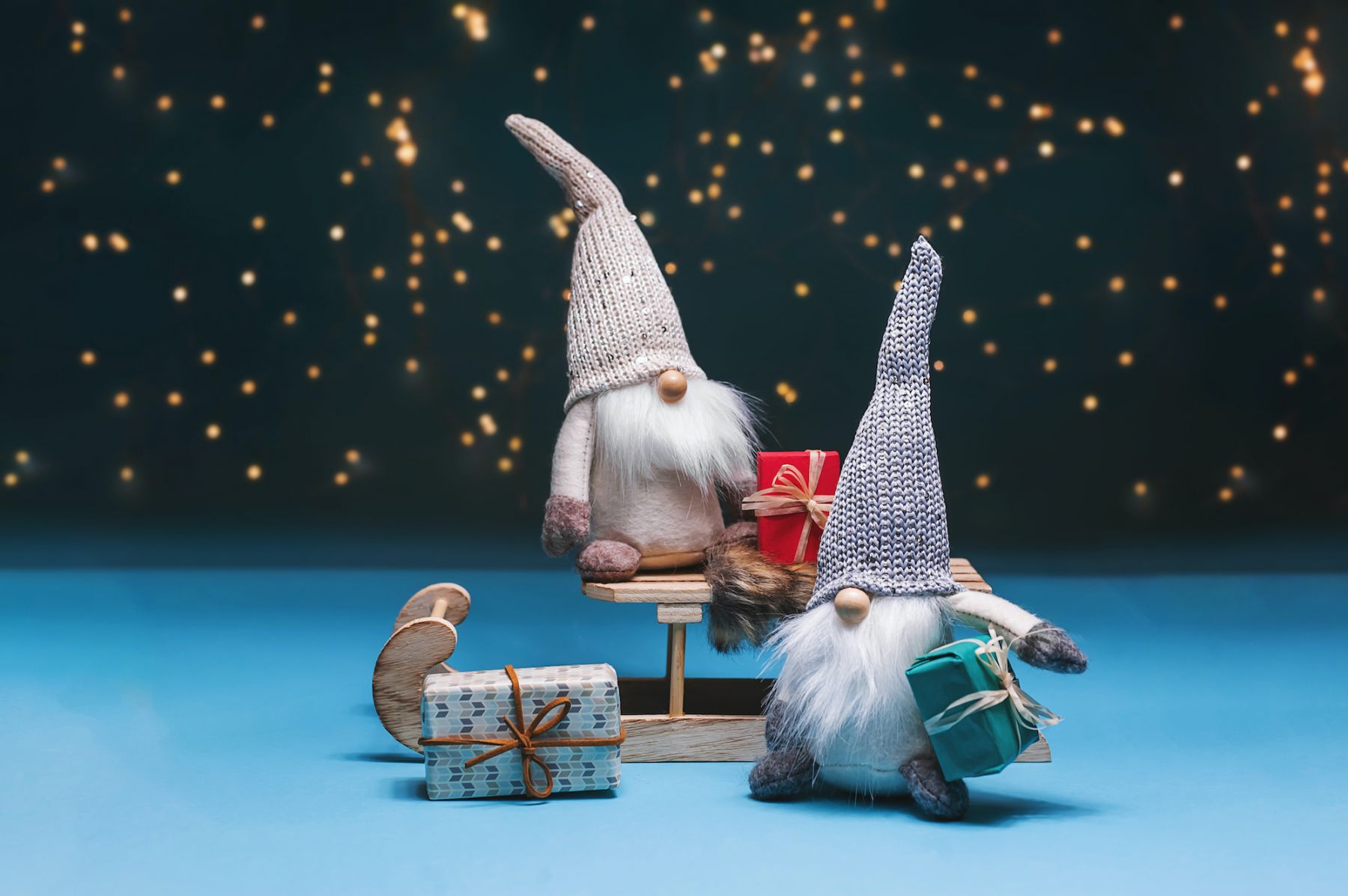 Nisser in Norway and Denmark, Tomtar in Sweden or Tonttu in Finnish, Scandinavian folk elves, northern Christmas motif, Tomte standing against the starry sky with gifts and sledges.