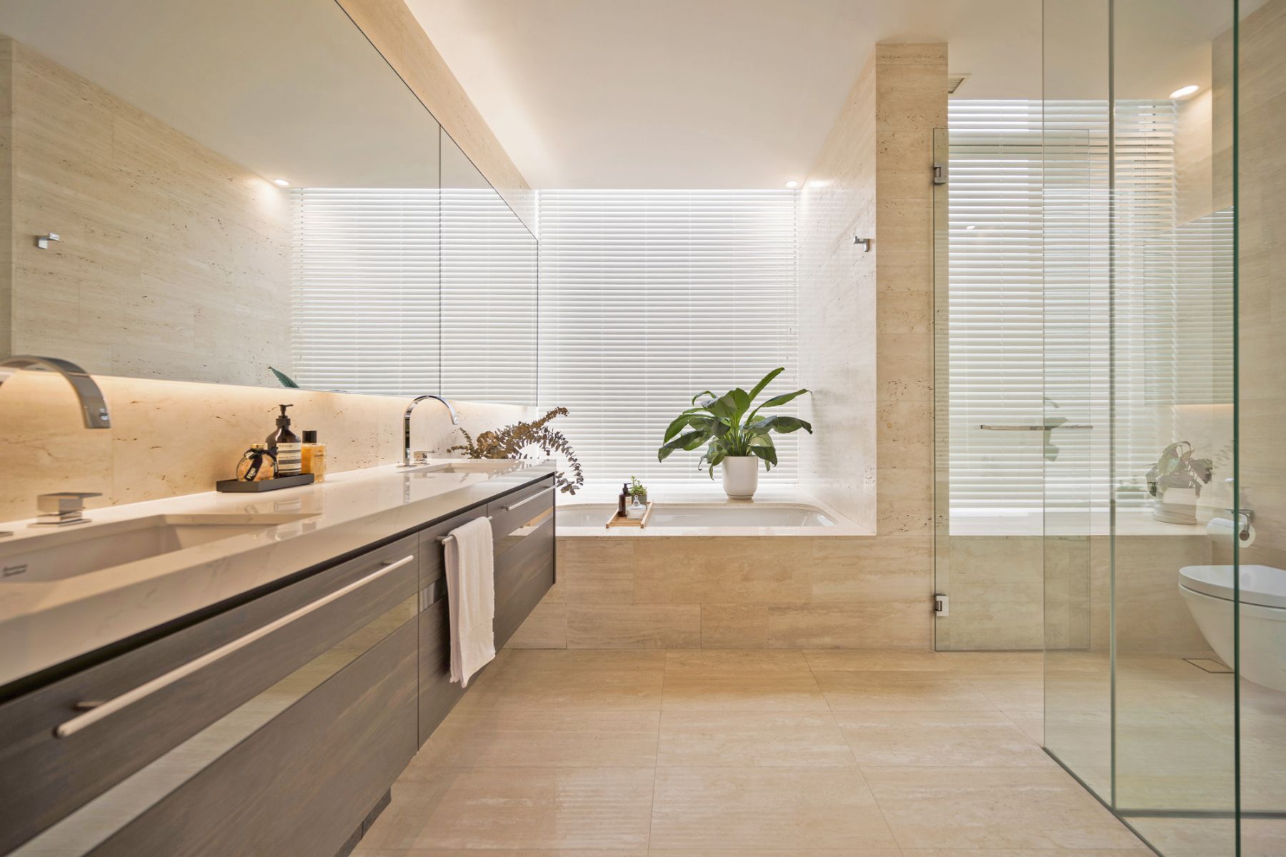 The master bathroom is a tranquil respite luxuriously clad in natural stone