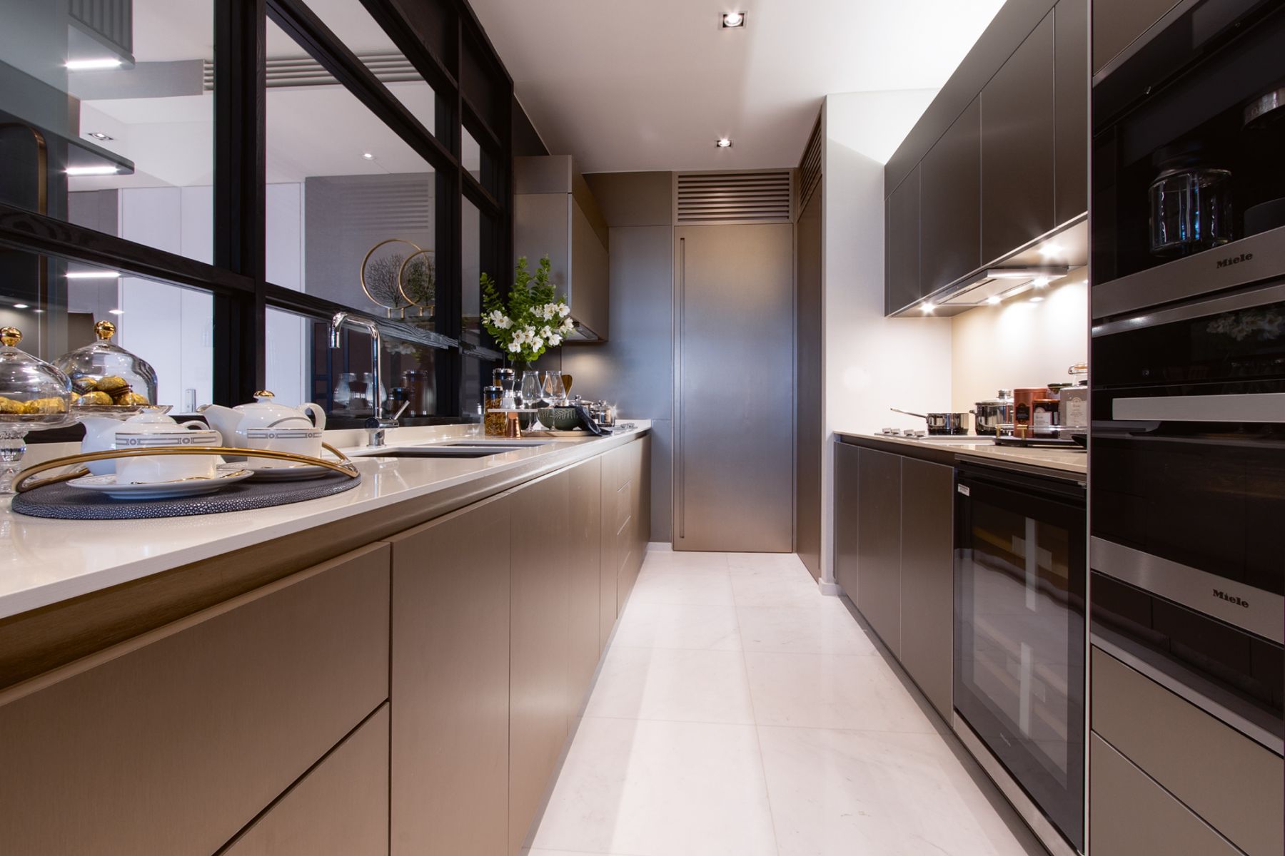 The kitchen features cabinetry in an earthy scheme and appliances from Miele