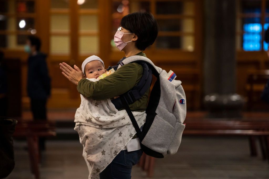 TAIPEI - MARCH 17 : A mother prays with her baby at the Hsing Tian Kong temple on March 17, 2020 in Taipei, Taiwan. Taiwan, Singapore and Hong Kong have had more successful approaches in battling the pandemic given their experience with SARS in 2003. According to CDC current totals the Coronavirus ( COVID-19) has now affected 235,939 globally, killing 9,874. It has spread to 157 countries. (Photo by Paula Bronstein/Getty Images )
