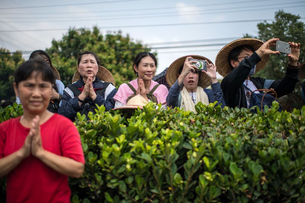 DADU, TAIWAN - APRIL 14: Women pray and take photographs as the sedan chair carrying a statue of the goddess Mazu is carried past on day two of the nine day Mazu pilgrimage on April 14, 2018 in Dadu, Taiwan. The annual Mazu Pilgrimage begins at Jenn Lann Temple in Taichung and sees around 200,000 pilgrims walk up to 12 hours each day for nine days carrying a statue of Chinese sea goddess Mazu in a sedan chair. The journey covers around 350 kilometres, much of it through mountainous and rugged terrain and vi