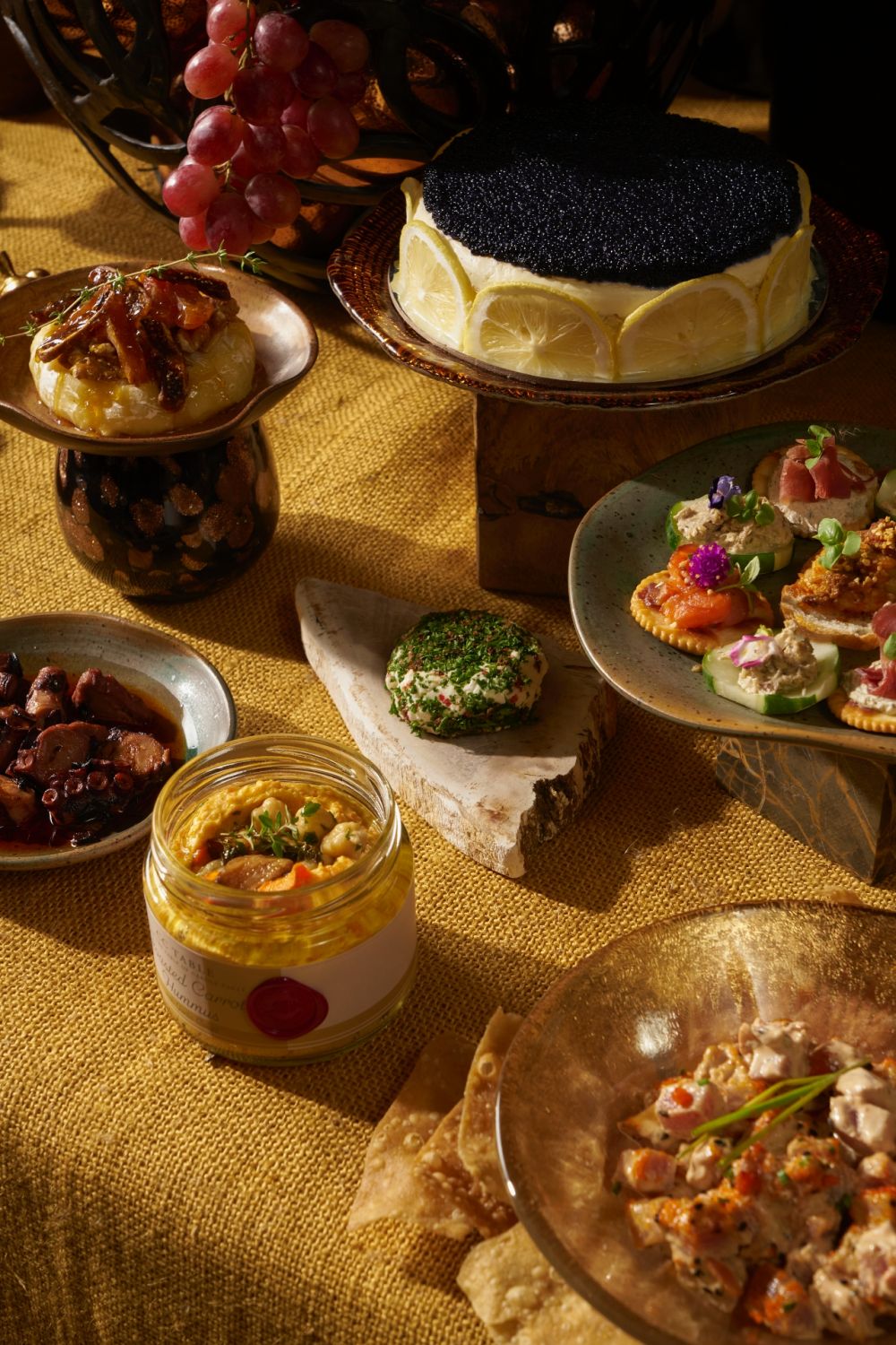L-R: Roasted carrot hummus from CC Table; pulpo a la gallega and herb coated goat cheese from Deli by Chele; caramelised petit Cambembert form Lusso; caviar pie by Marielle Po; canapes from Etxeko; tuna tartare from Tarucs | Photo by Sonny Thakur