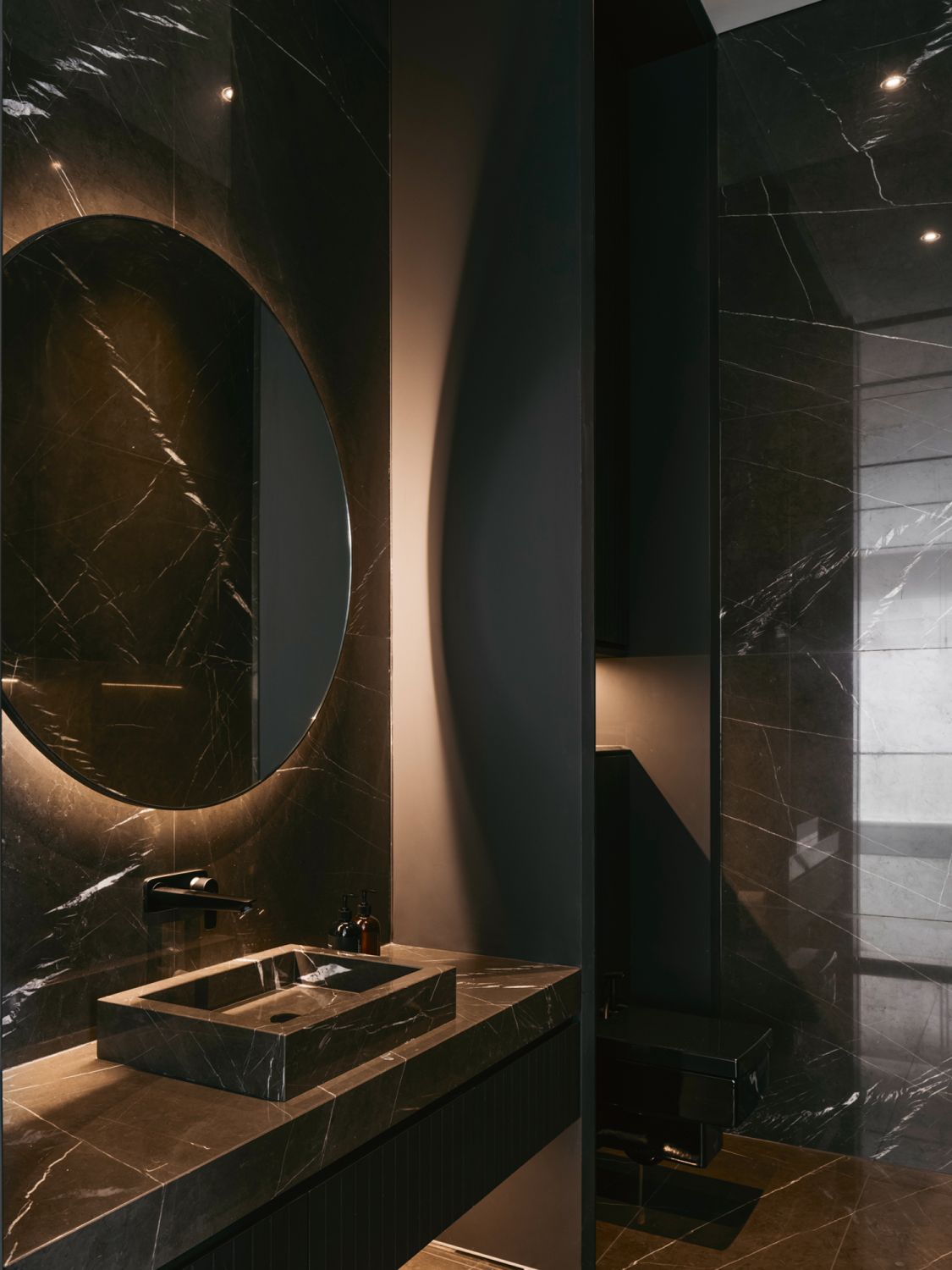 Pietra grey marble tiles contribute to the sophisticated look of this powder room