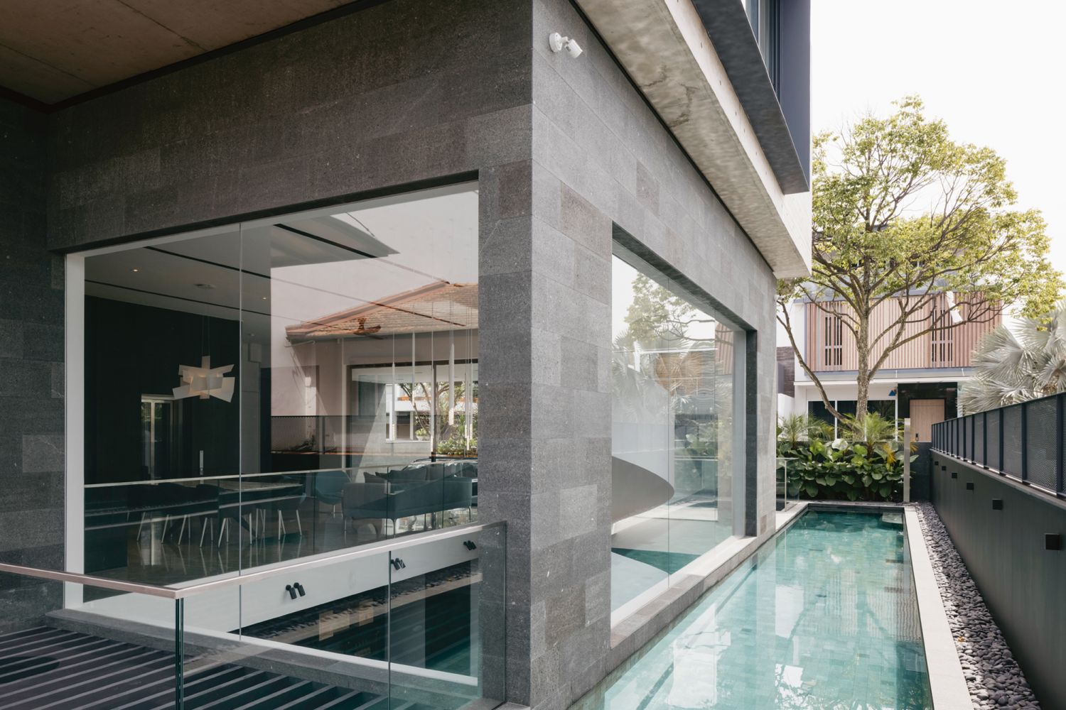 Cyan-hued tiles and outdoor plants contribute to the serene vibe of the lap pool