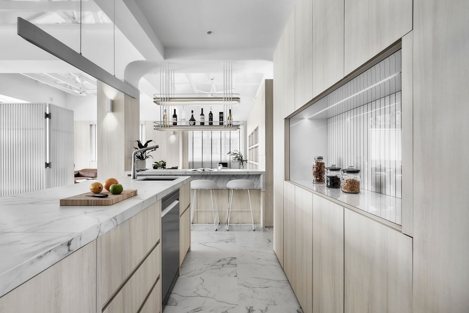 The dry kitchen is fitted with marble countertops and cabinetry featuring light wood finishings