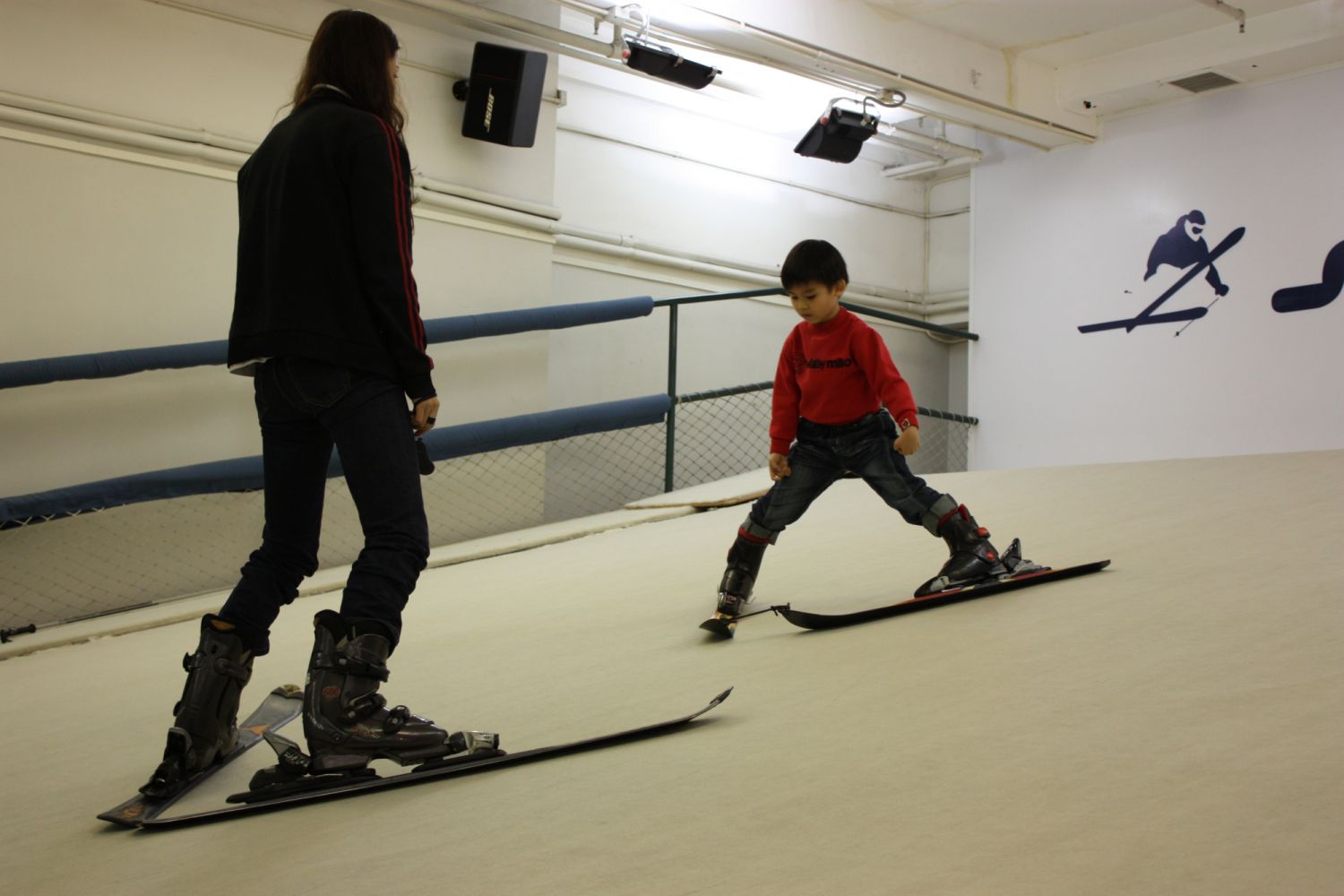 A Slope Infinity instructor teaches a child the snow plough technique
