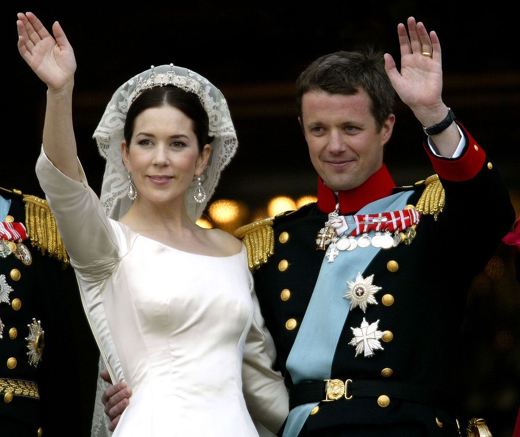 COPENHAGEN, DENMARK - MAY 14: Crown Princess Mary and Crown Prince Frederik of Denmark wave from the balcony of Christian VII's Palace after their wedding on May 14, 2004 in Copenhagen, Denmark. The romance began in 2000 when Miss Mary Elizabeth Donaldson met the heir to one of Europe's oldest monarchies over drinks at the Sydney Olympics, where he was with the Danish sailing team. (Photo by Ian Waldie/Getty Images)
