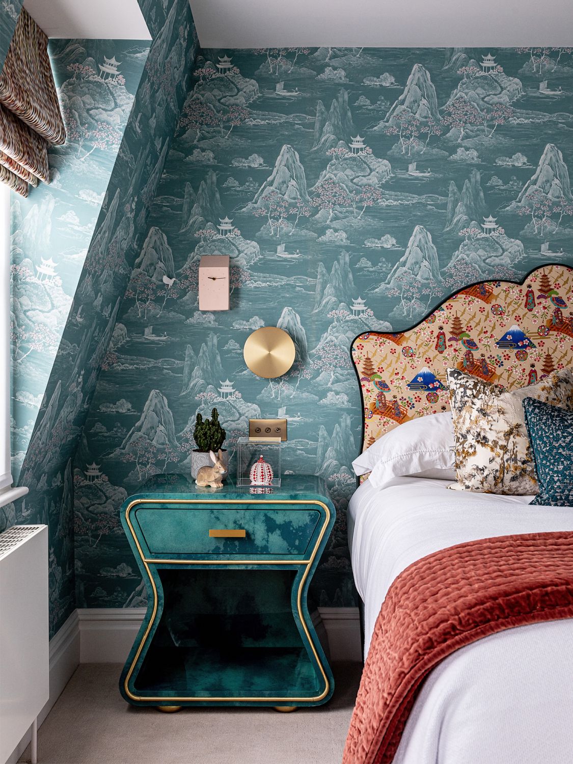 The teal vellum side tables with brass details pay homage to the Art Deco period
