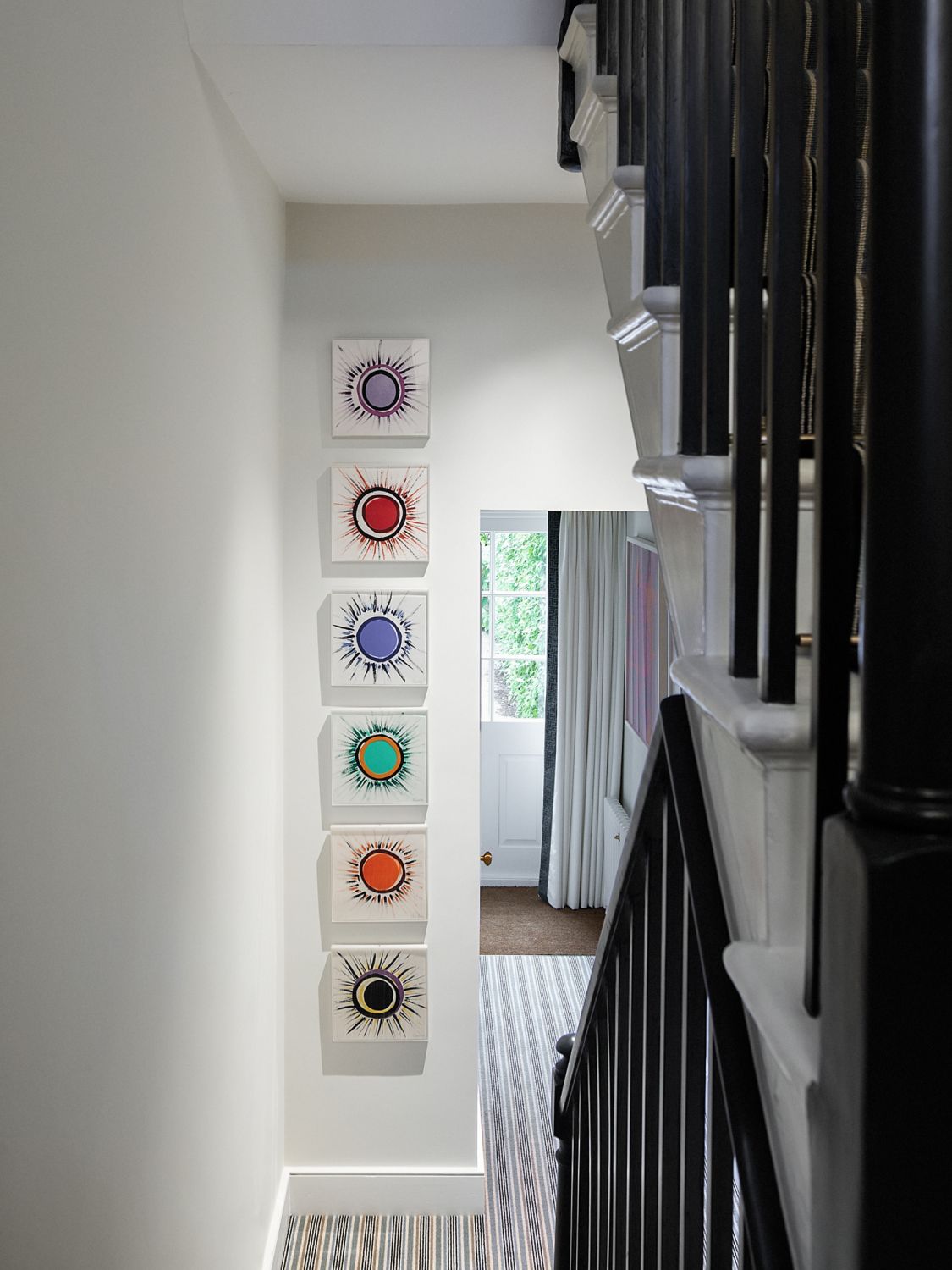 The white walls serve as the ideal backdrop for the joyful mix of art