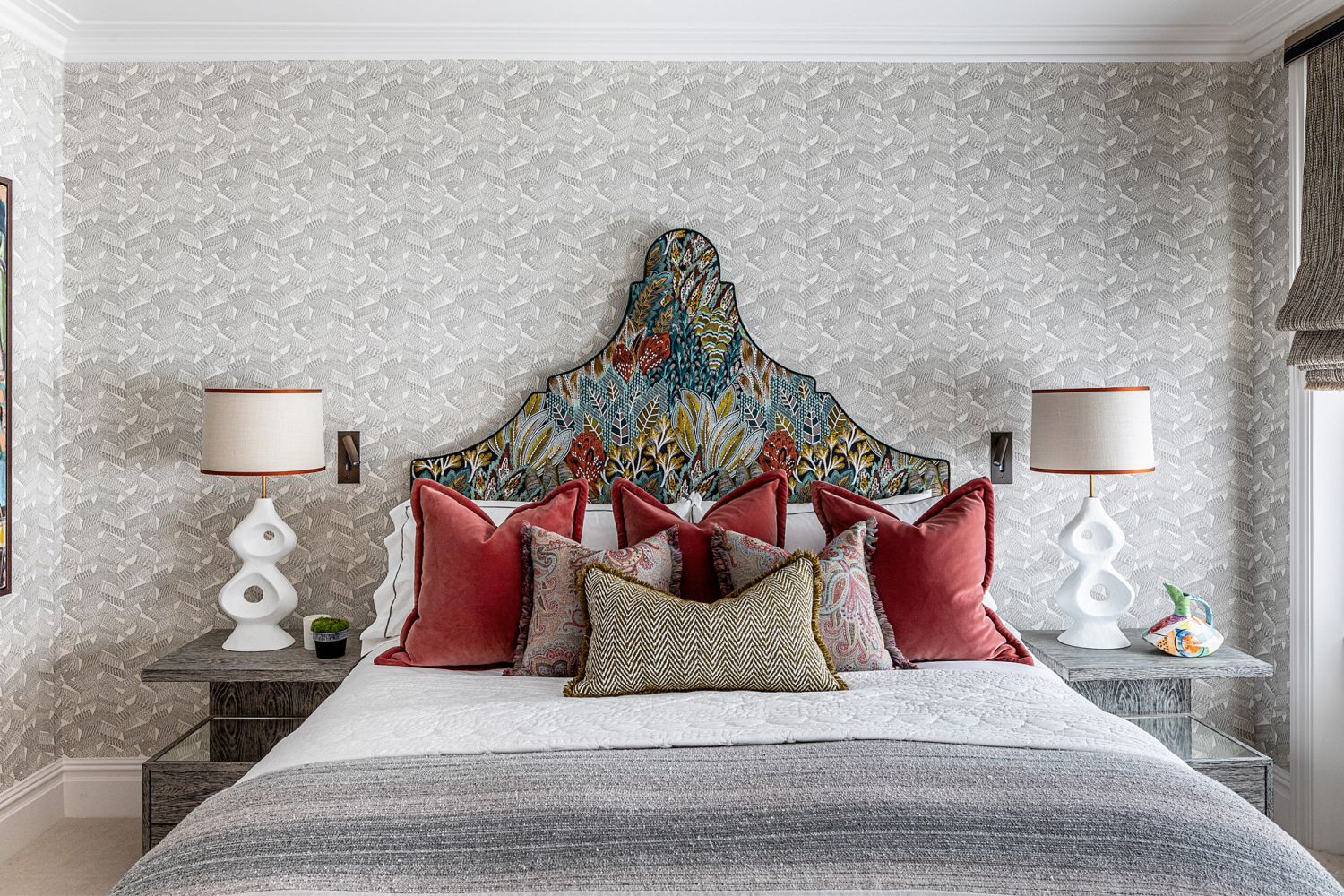 The master bedroom emits cosy comfort with soft cotton sheets, a quilted bedspread, a sheer grey throw and soft velvet, herringbone and paisley cushions